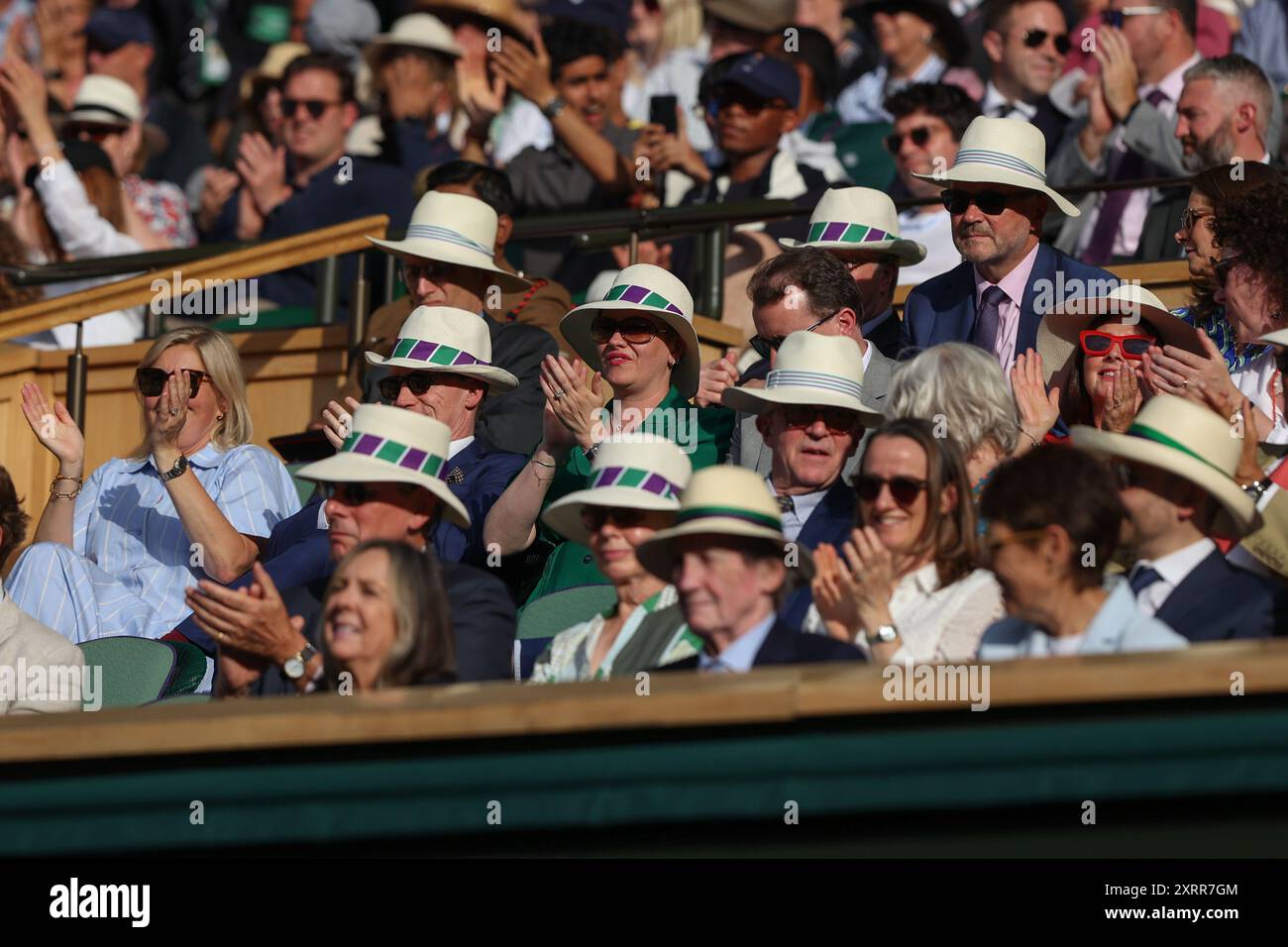 Spectateurs dans la Royal Box portant des chapeaux au soleil sur le court central aux championnats de Wimbledon 2024, Londres, Angleterre. Banque D'Images