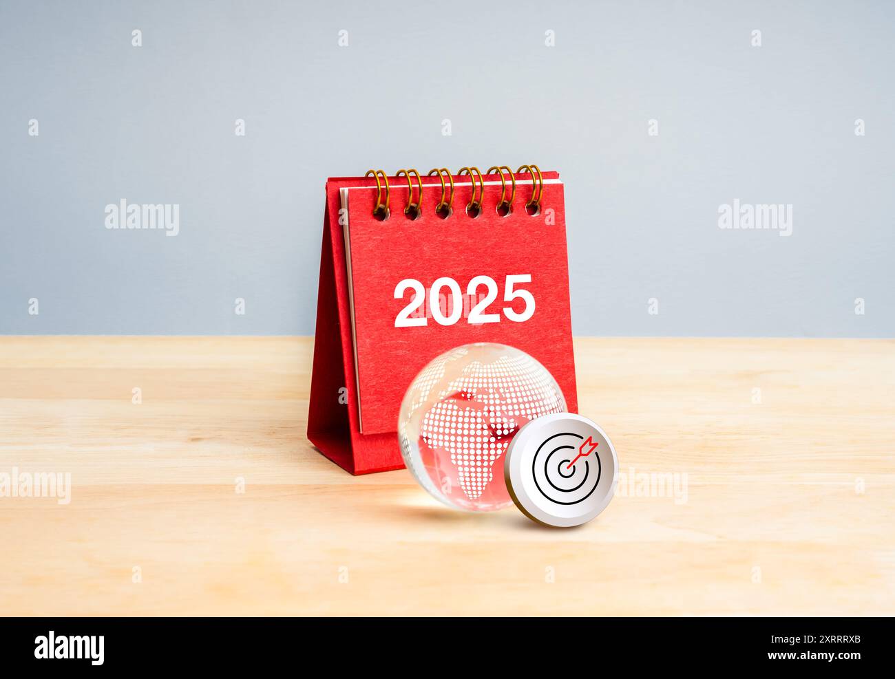 Bonne année 2025 avec les affaires mondiales, le marketing numérique, l'objectif et le concept de technologie. Icône cible 3d avec calendrier rouge 2025 près du globe terrestre en verre Banque D'Images