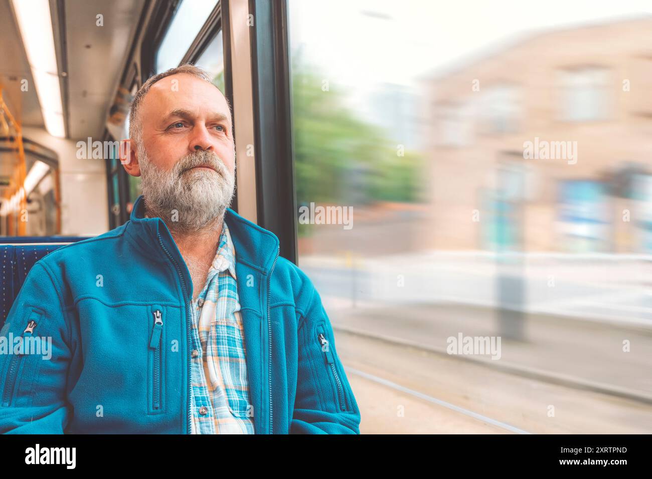 homme barbu heureux en veste chaude bleue dans un bus ou un tram. Concept de style de vie Banque D'Images