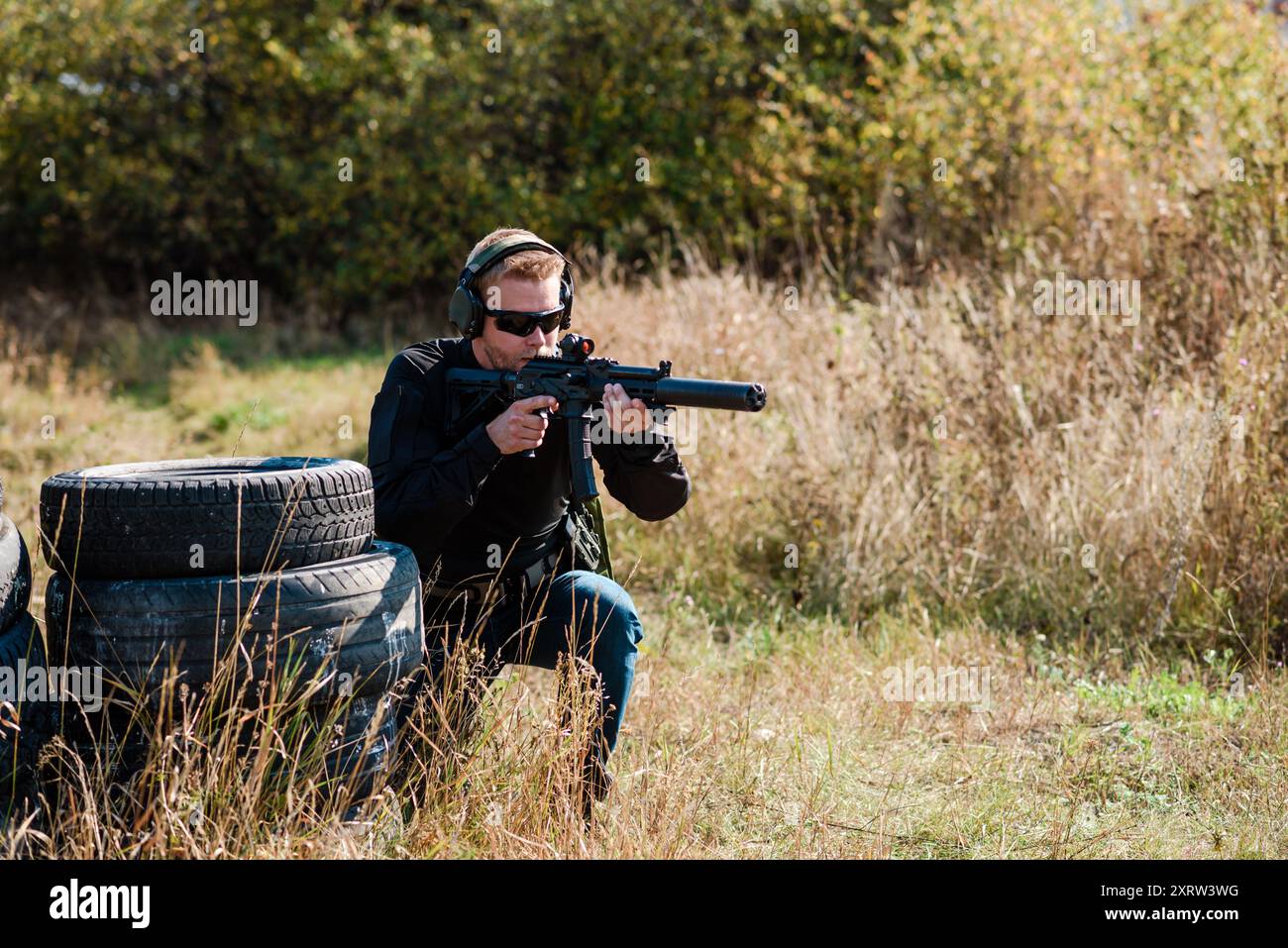 Un homme avec une mitrailleuse à la main suit un entraînement militaire et apprend à tirer sur le champ de tir Banque D'Images