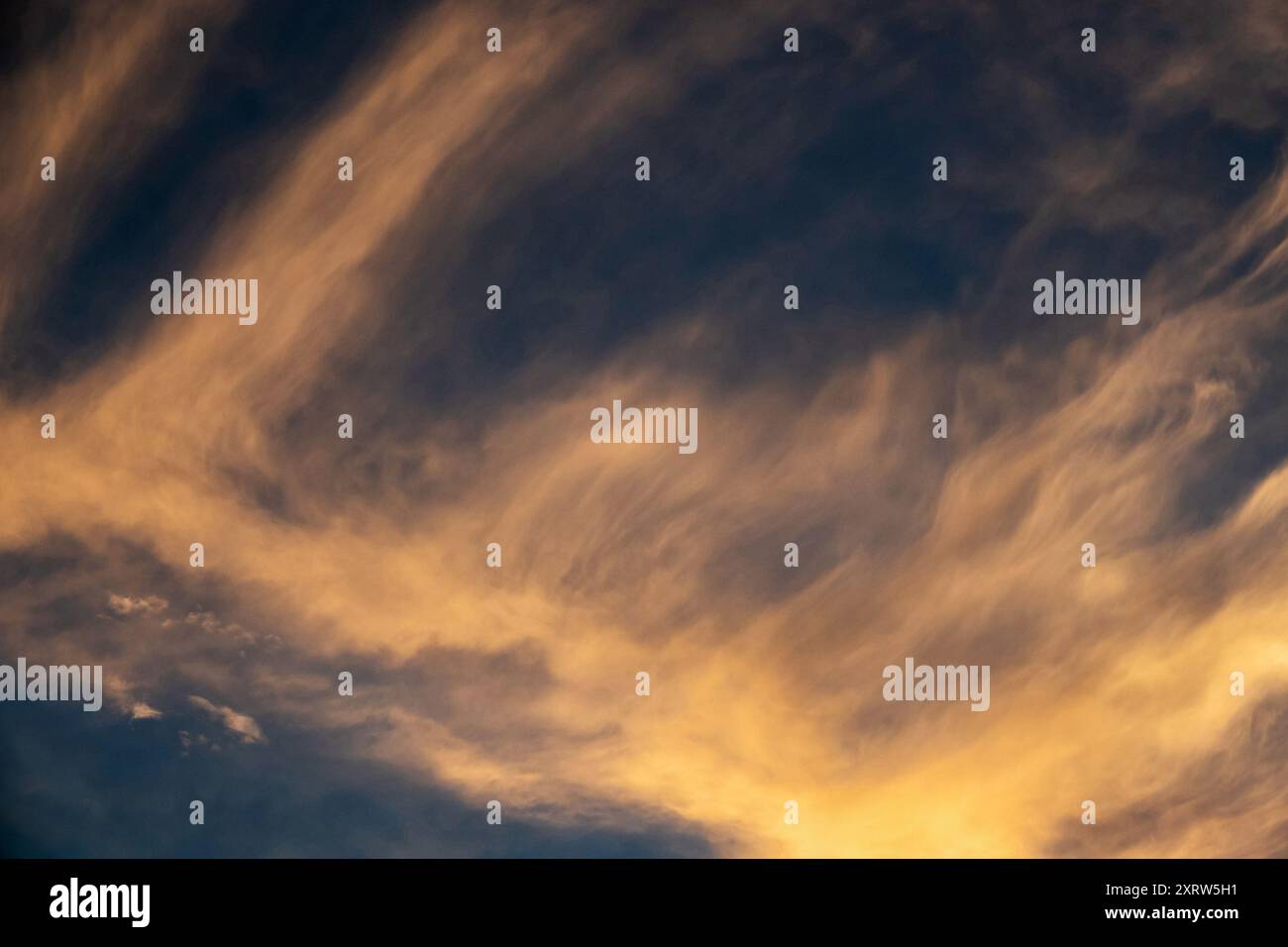 Le soleil couchant crée une peinture pastel abstraite du ciel et des nuages. Banque D'Images
