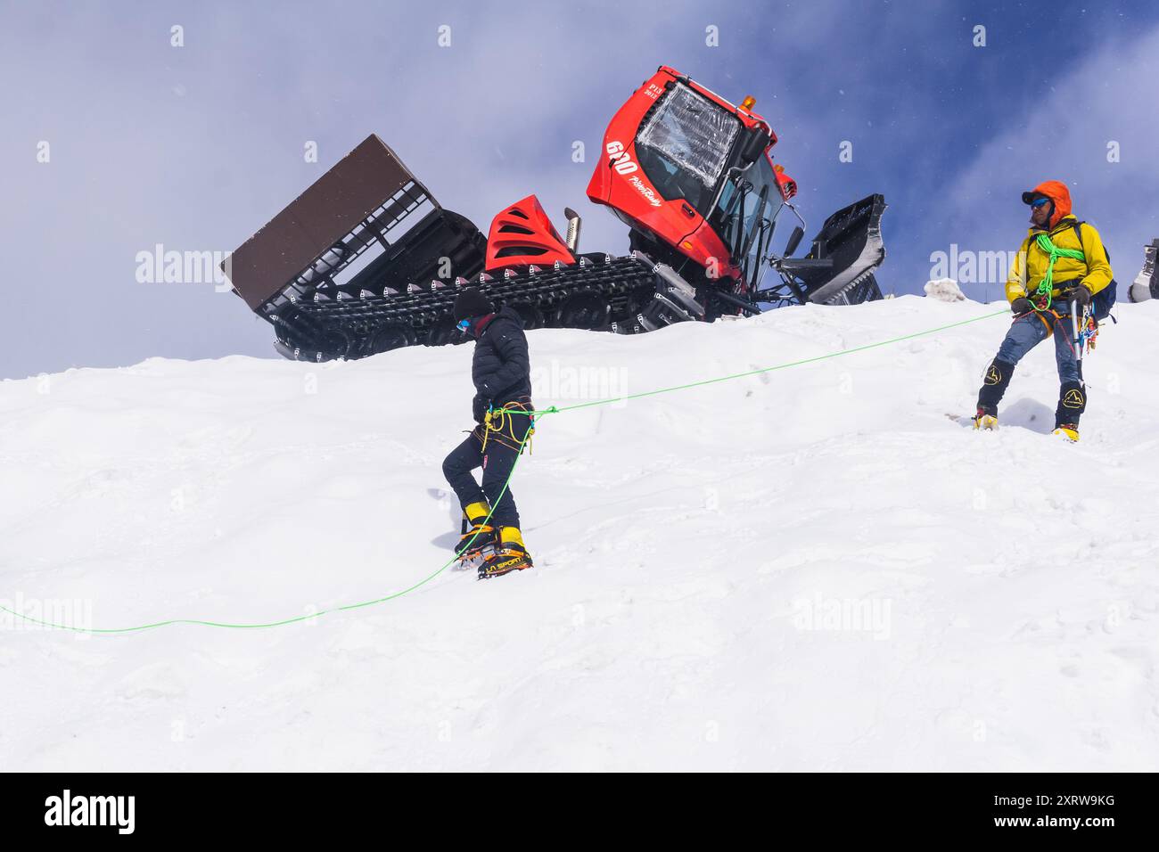 Elbrus, Russie - 01 août 2024 : les grimpeurs pratiquent leurs compétences d'escalade sur une pente enneigée avec des chats à neige en arrière-plan Banque D'Images