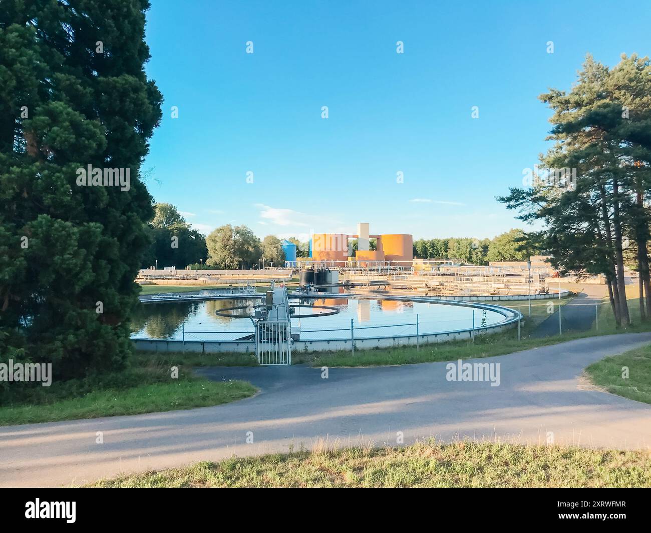 Un grand plan d'eau est entouré d'arbres et d'un bâtiment. L'eau est calme et paisible, et les arbres procurent un sentiment de tranquillité Banque D'Images