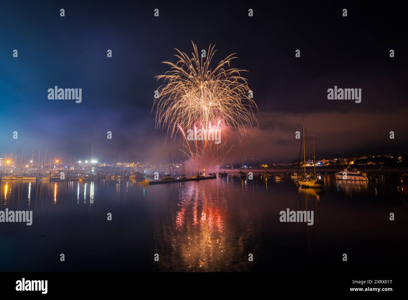 Plan d'exposition longue de feux d'artifice colorés au-dessus de la mer pour les festivités locales à Portonovo, Sanxenxo, Galice. Banque D'Images