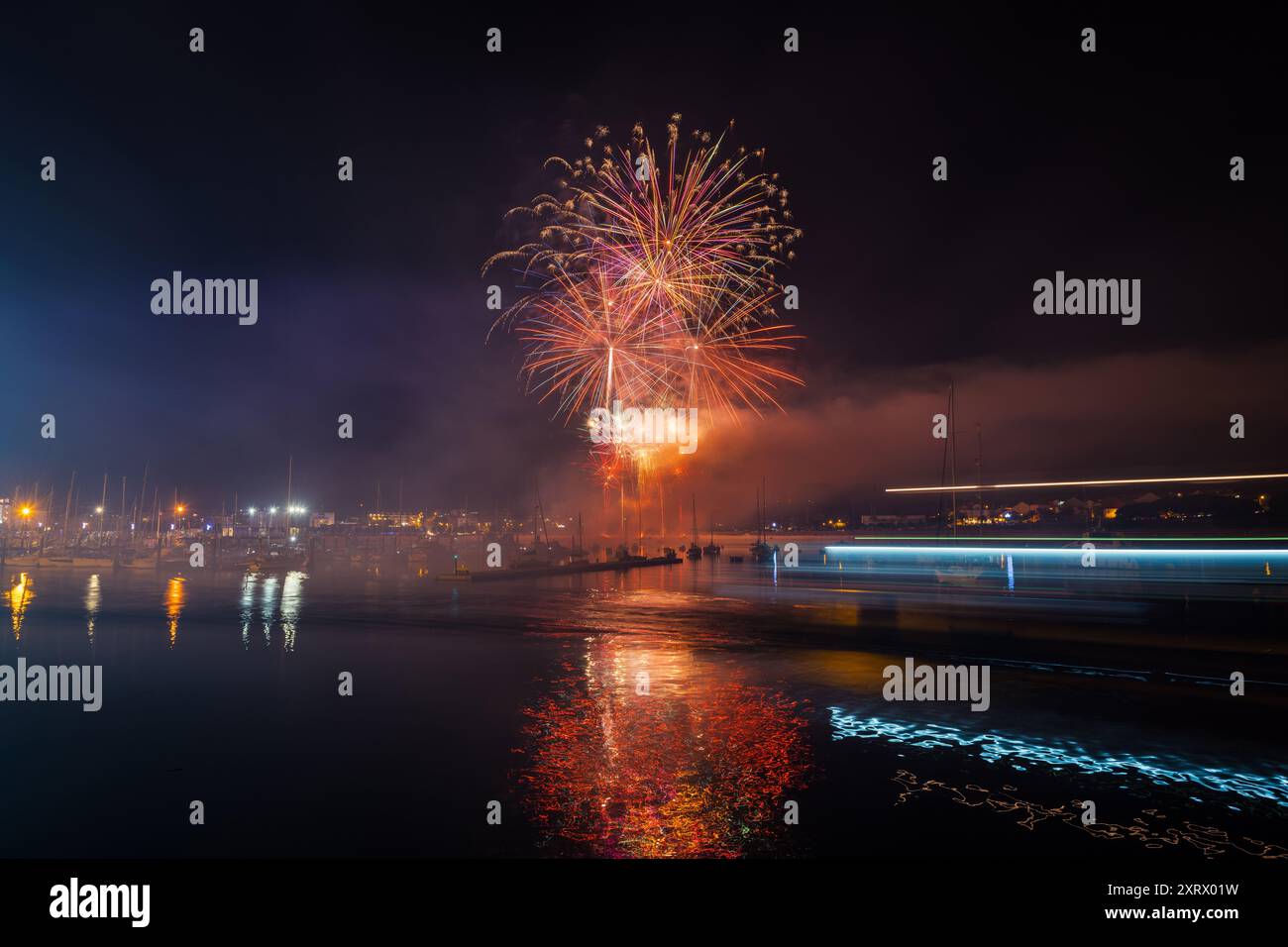 Plan d'exposition longue de feux d'artifice colorés au-dessus de la mer pour les festivités locales à Portonovo, Sanxenxo, Galice. Banque D'Images