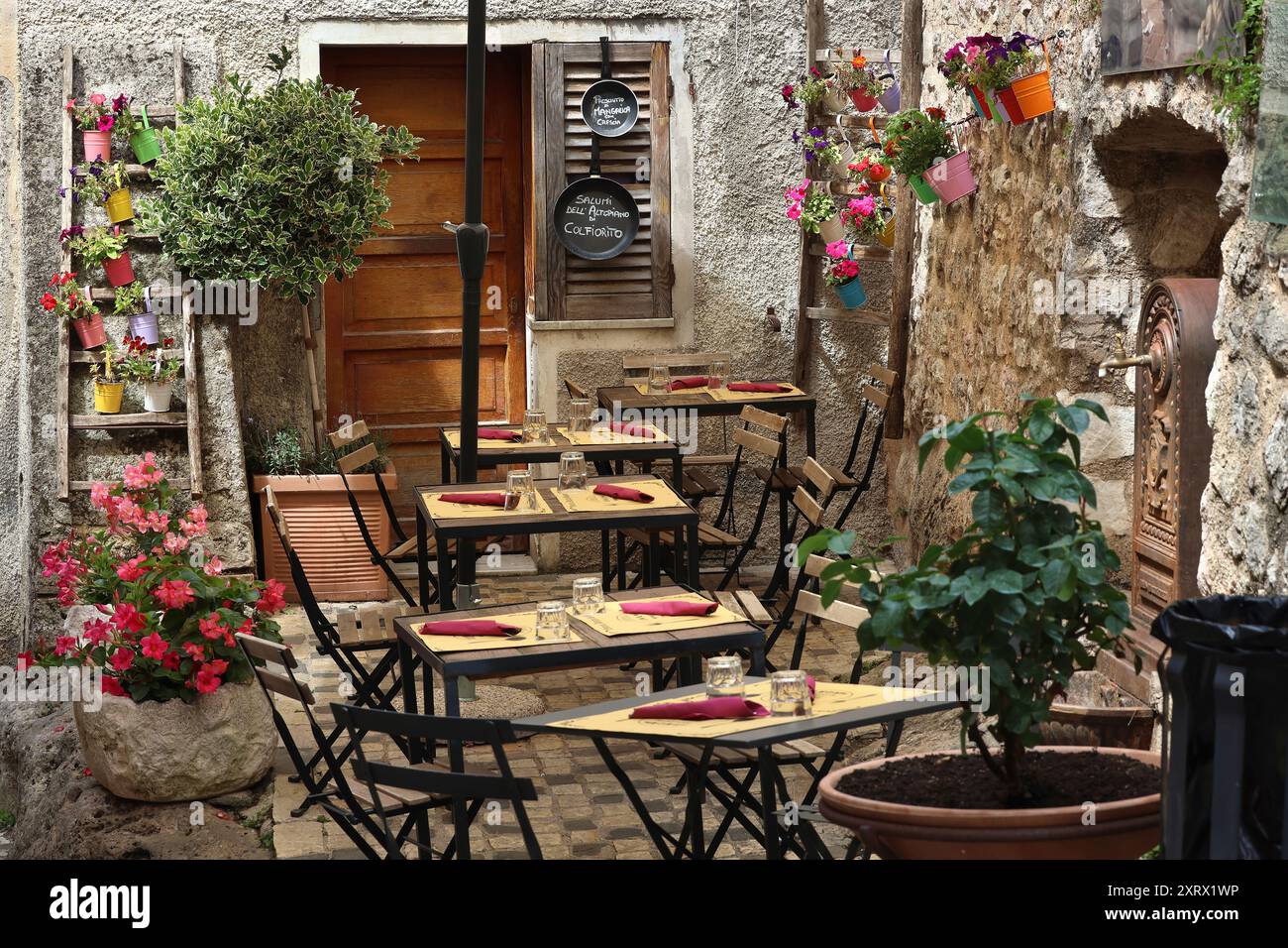 Un charmant restaurant italien rustique avec beaucoup de pots de fleurs. Banque D'Images