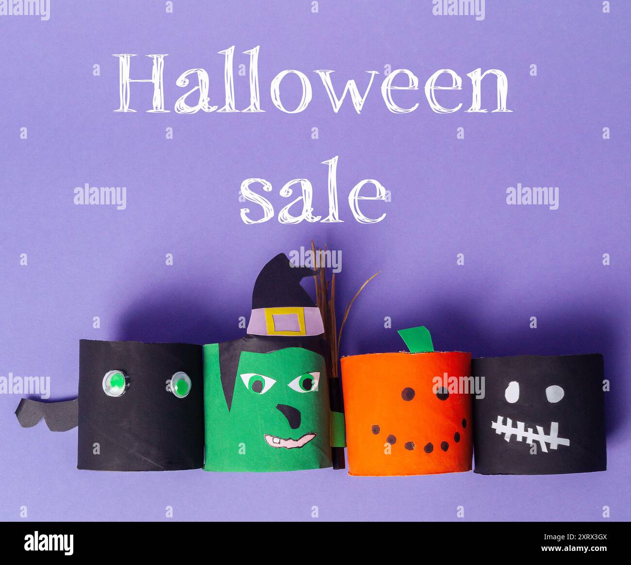 Solde d'Halloween avec quatre découpes en papier de personnages d'Halloween. Les personnages sont une sorcière, une citrouille, un squelette et un fantôme Banque D'Images