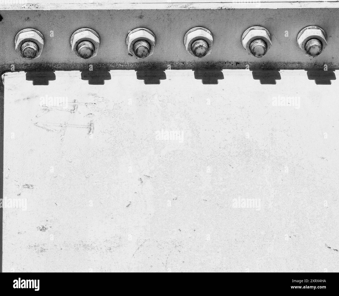 Vis rouillées sur construction de pont en métal blanc : jeu de lumière et d'ombre. Monochrome. Banque D'Images