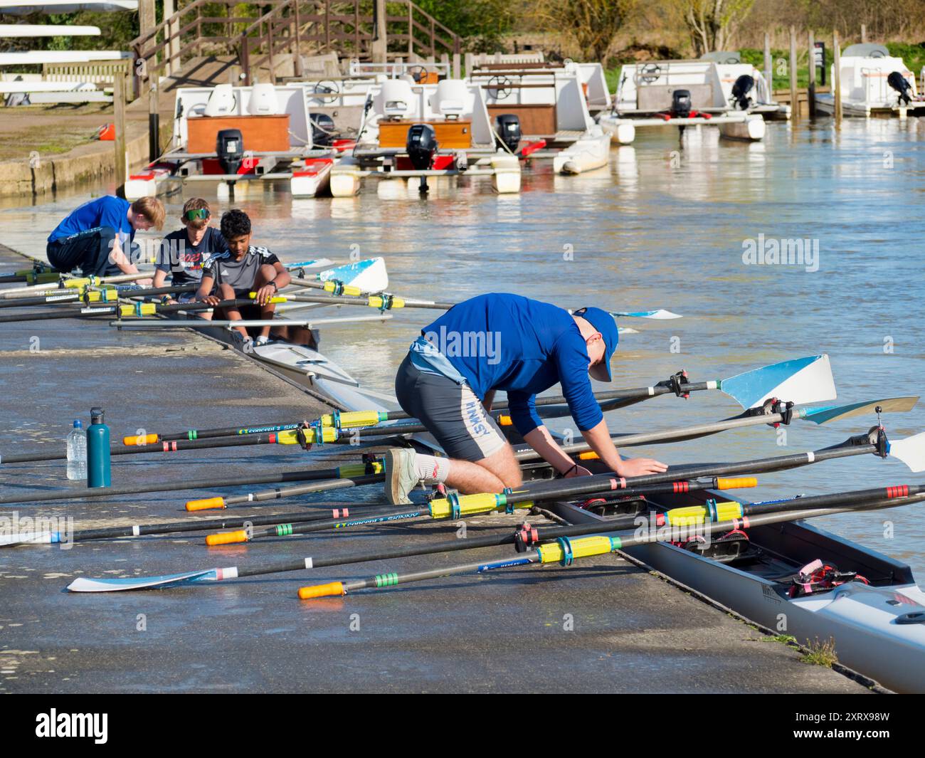 Fondé en 1921 et situé sur une belle partie de la Tamise dans l'Oxfordshire, Radley Boathouse sert Radley College et les amateurs d'aviron locaux depuis plus d'un siècle. Il sert également d'hôte pour les écoles de formation de week-end pour aider les jeunes à apprendre à aviron en tant que sport. Ici, nous voyons un tel événement, un beau matin tôt le printemps. Banque D'Images