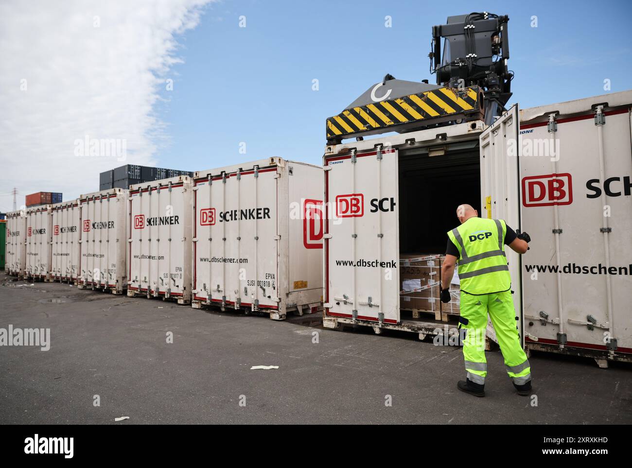 Hambourg, Allemagne. 08 août 2024. Un employé ferme un conteneur avec le logo de la société au DB Schenker Logistics Center Port de Hambourg chez DCP Dettmer Container Packing GmbH dans le port de Hambourg. Crédit : Christian Charisius/dpa/Alamy Live News Banque D'Images