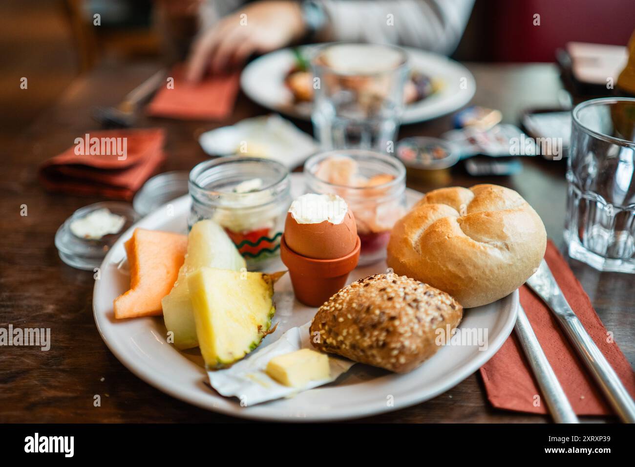 Œuf bouilli craqué ouvert au milieu d'une assiette de petit déjeuner complet Banque D'Images