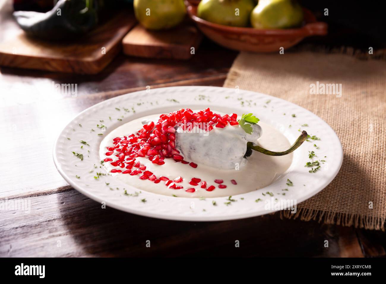 Chiles en Nogada, plat typique du Mexique. Préparé avec du piment poblano farci à la viande et aux fruits et recouvert d'une sauce aux noix, persil et pépins Banque D'Images