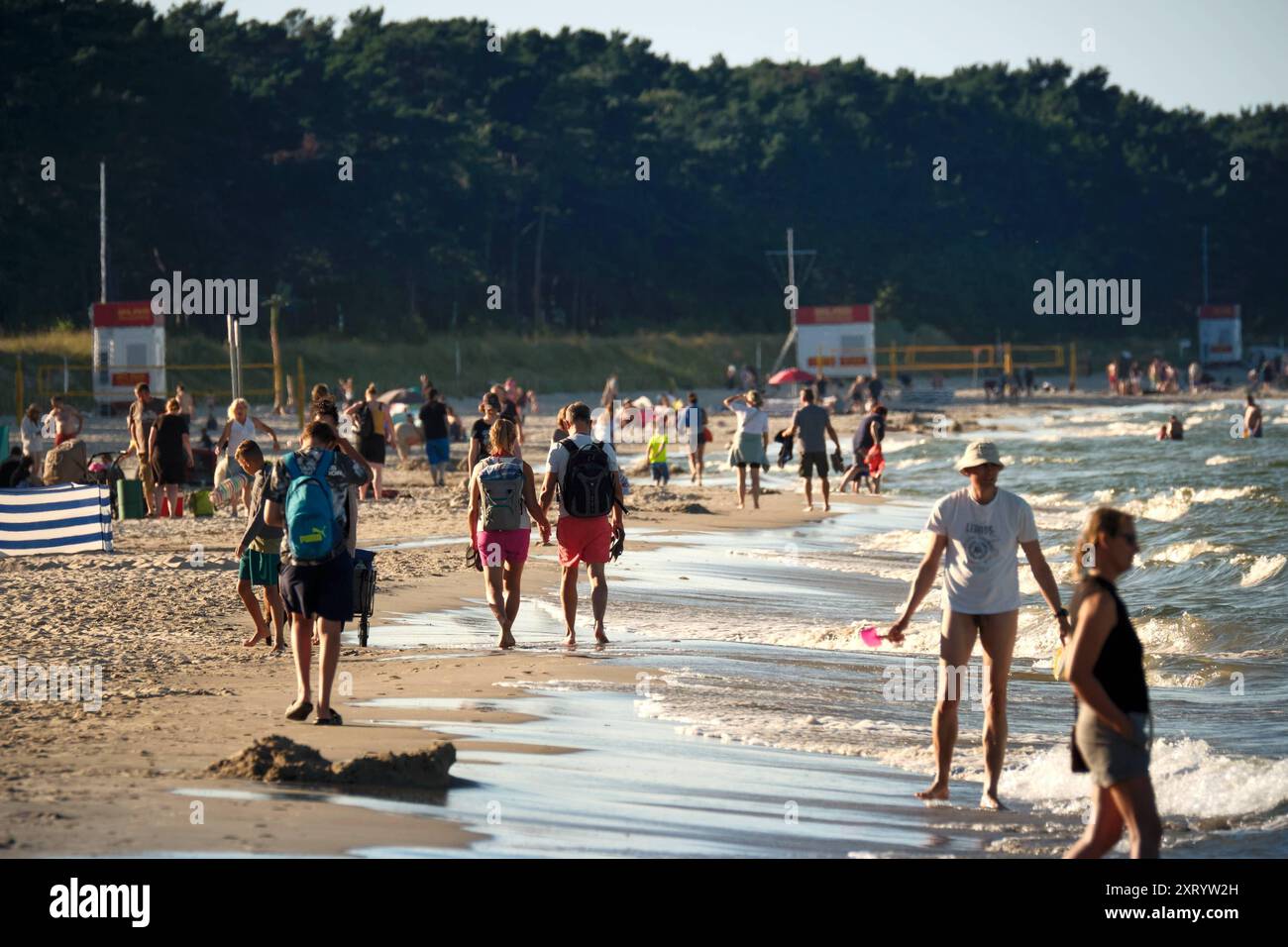 12.08.2024 AM Strand von Binz auf der Insel Rügen in Mecklenburg-Vorpommern gehen Urlauber an der Wasserkante entlang, schauen sich die die Wellen an und genießen die Abendsonne. Der Ort ist das größte Seebad auf der Insel. Binz ist das größte Seebad auf der Insel Rügen. Die Gemeinde gehört zum Landkreis Vorpommern-Rügen in Mecklenburg-Vorpommern. DAS Ostseebad trägt seinen Titel seit 1885 und ist Anziehungspunkt und Urlaubsort für Alle, die Natur, Strand und Entspannung lieben. Binz Ostsee Mecklenburg-Vorpommern Deutschland *** 12 08 2024 sur la plage de Binz sur l'île de Rügen dans le Mecklen Banque D'Images