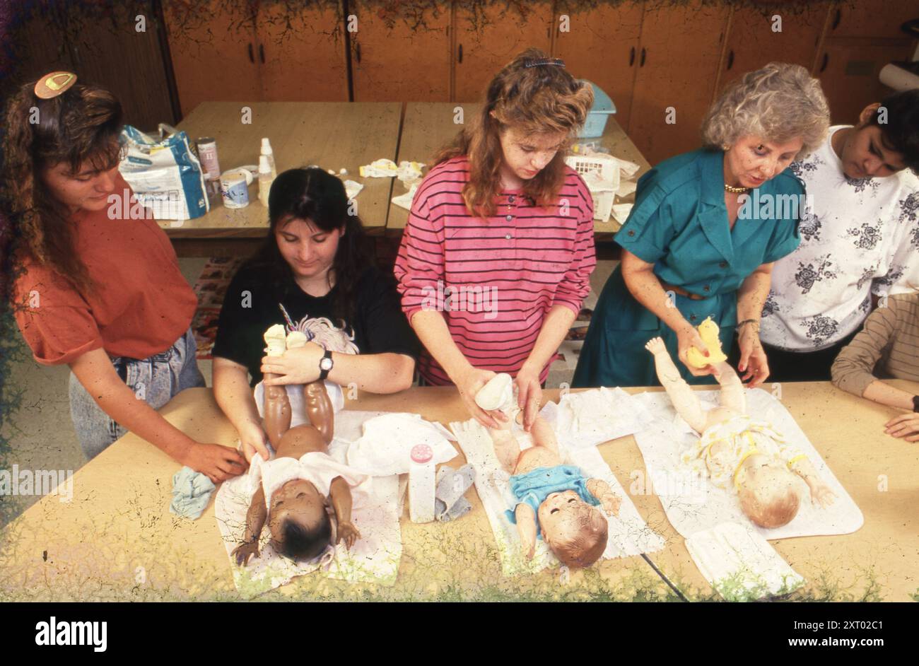 Austin Texas USA, 1994 : les lycéennes utilisent des poupées pour apprendre à mettre une couche sur un bébé pendant la classe d'économie domestique à Johnston High School. ©Bob Daemmrich Banque D'Images