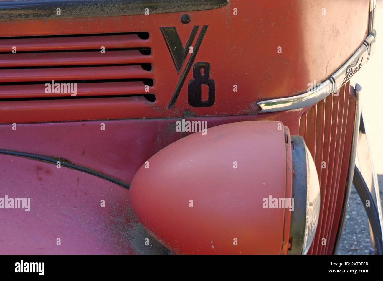 Gros plan d'un phare et d'une grille d'un vieux pick-up Ford rouge des années 1940 Banque D'Images