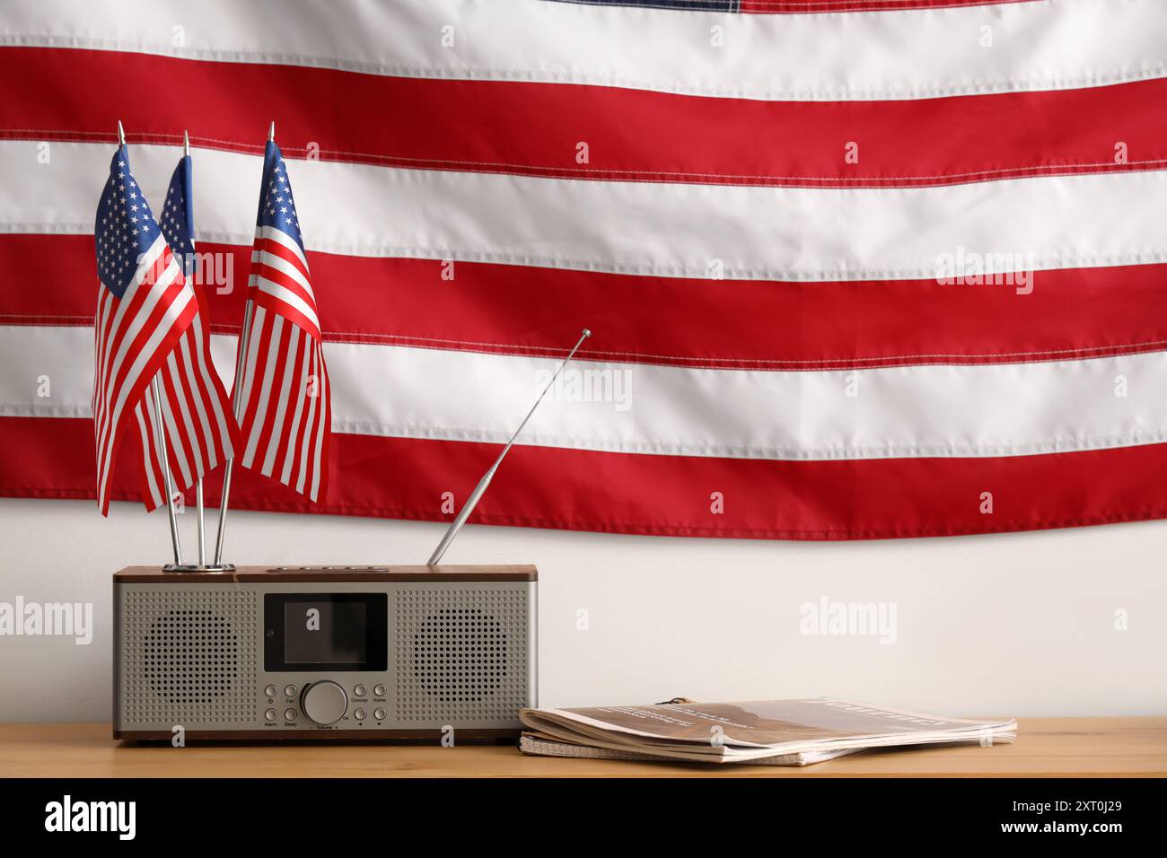 Drapeaux USA, radio rétro et magazines sur table en bois Banque D'Images