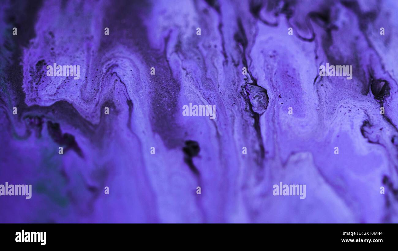 Déversement de néon. Texture pétillante. Émulsion de mélange liquide de peinture de couleur noire pourpre défocalisée répandant le fond d'art abstrait. Banque D'Images