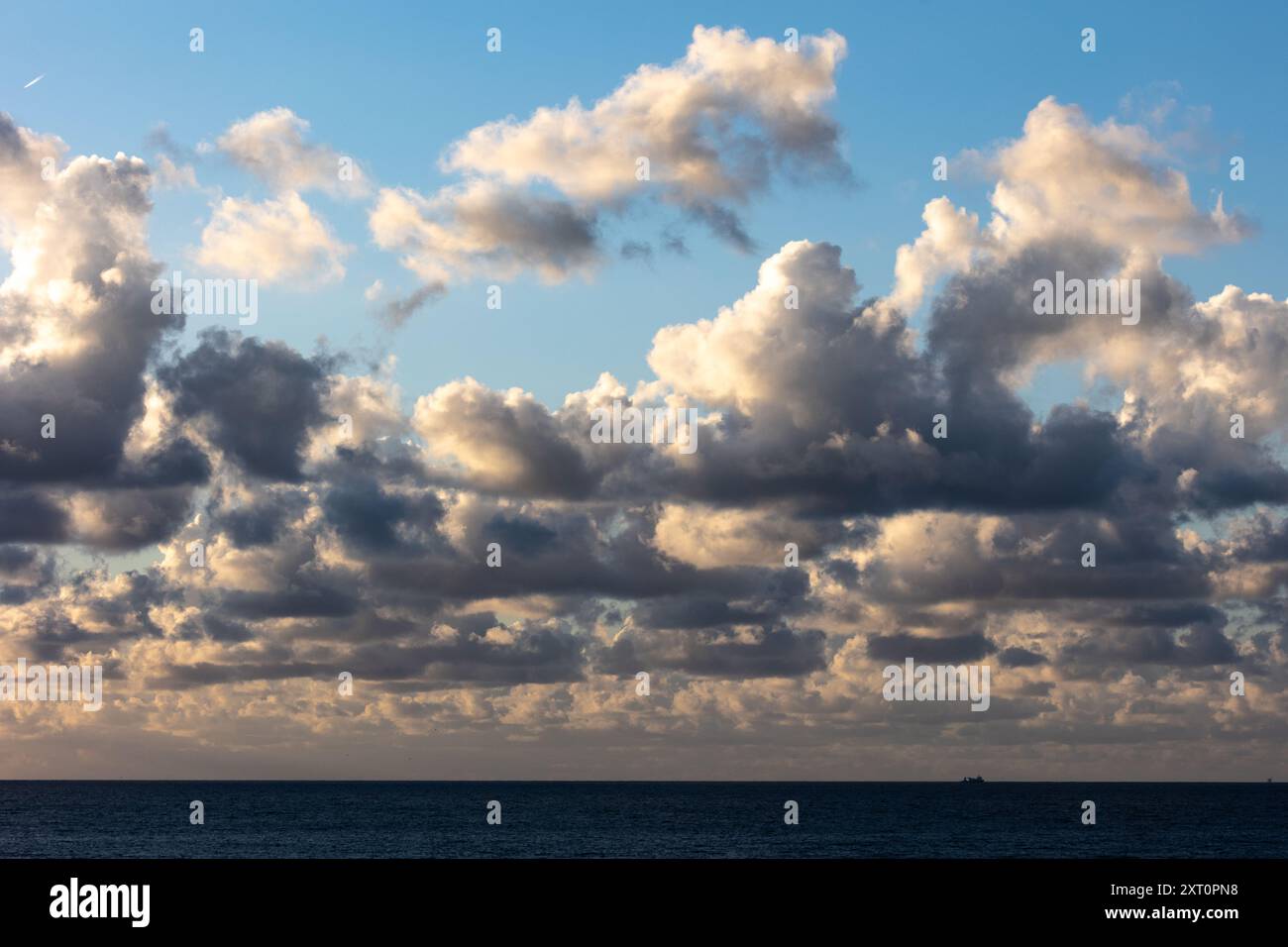 Nuageux au-dessus de la mer avec des nuages sombres d'en bas et des nuages blancs dans le soleil d'en haut Banque D'Images