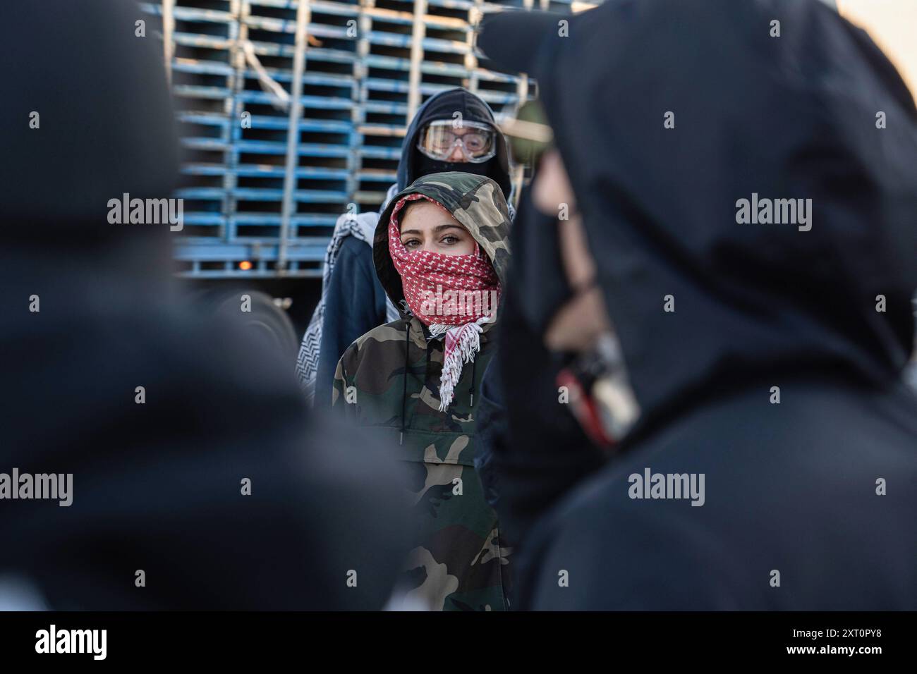 Melbourne, Australie. 13 août 2024. Un manifestant a vu regarder la caméra parmi la foule pendant la manifestation. Les manifestants pro-Palestine se sont rassemblés pour une manifestation devant Un W. Bell à Dandenong South Melbourne, une entreprise qui fabrique des pièces pour Israël. La manifestation a duré près de 5 heures, elle a pris fin après qu'ils aient reçu un déménagement sur ordre de la police et ont été surpassés en nombre. Les travailleurs de A.W.Bell ont pu commencer leur quart de travail lorsque la police a créé une barrière contre les manifestants. Crédit : SOPA images Limited/Alamy Live News Banque D'Images