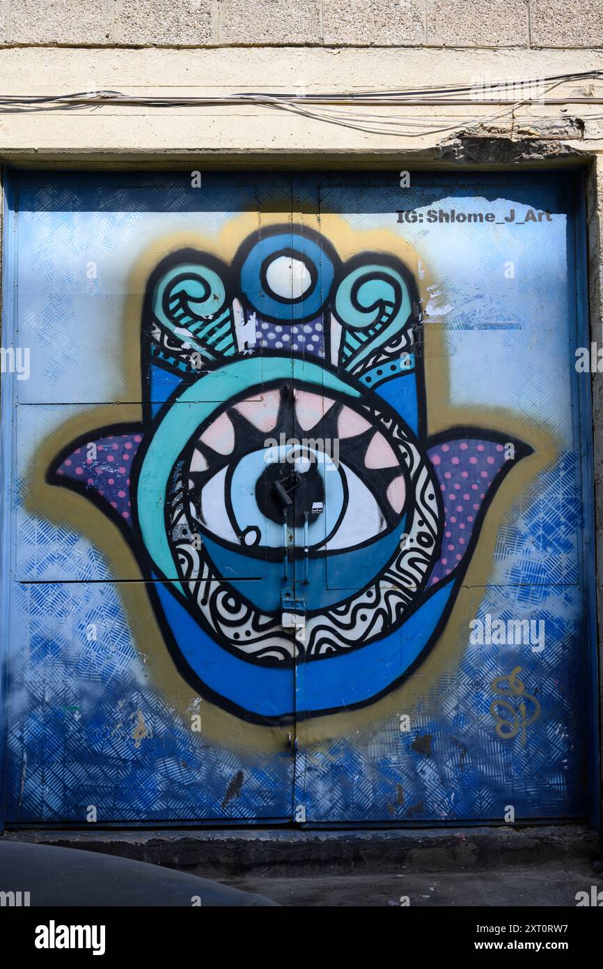 Graffiti coloré Hamsa sur un mur dans le quartier de Kiryat Hamelacha, tel Aviv, Israël Banque D'Images