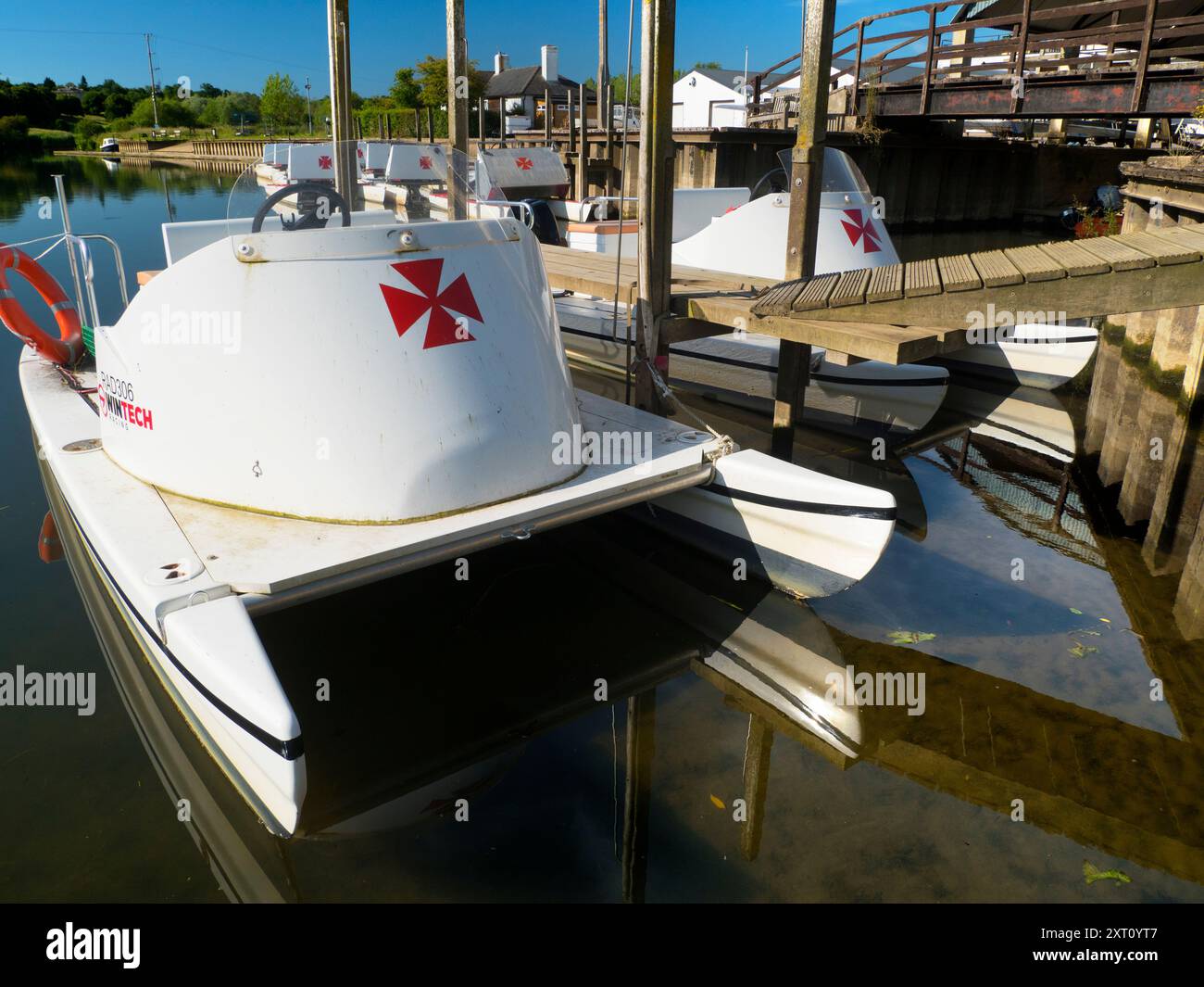 Fondé en 1921 et situé sur une belle partie de la Tamise dans l'Oxfordshire, Radley Boathouse sert Radley College et les amateurs d'aviron locaux depuis plus d'un siècle. Ici, nous voyons une ligne de bateaux de plaisance amarrés par sa jetée, tôt par un beau matin de printemps. Pourquoi la Croix de Malte ? C'est une longue histoire... Il a été adopté à l'origine par le Collège comme badge pour tous les sports vers 1850. Il est devenu le symbole du Boat Club à partir de la première équipe connue, et a probablement été adopté en l'honneur de Sir George Bowyer, le propriétaire de Radley Hall et à qui la maison et les terrains ont été loués quand t Banque D'Images