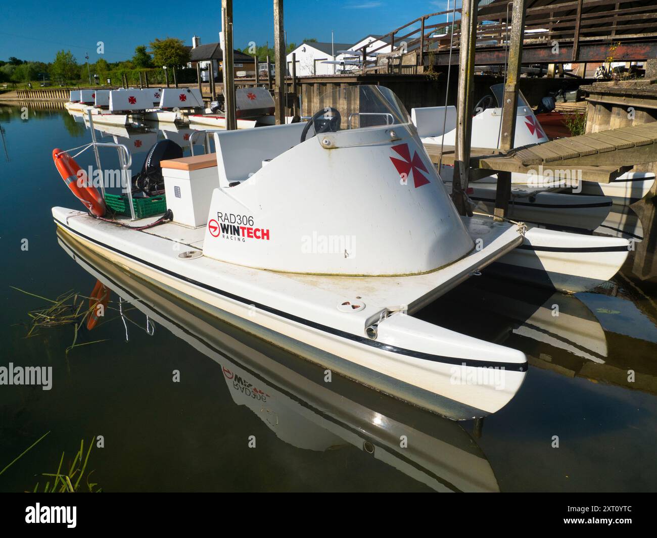 Fondé en 1921 et situé sur une belle partie de la Tamise dans l'Oxfordshire, Radley Boathouse sert Radley College et les amateurs d'aviron locaux depuis plus d'un siècle. Ici, nous voyons une ligne de bateaux de plaisance amarrés par sa jetée, tôt par un beau matin de printemps. Pourquoi la Croix de Malte ? C'est une longue histoire... Il a été adopté à l'origine par le Collège comme badge pour tous les sports vers 1850. Il est devenu le symbole du Boat Club à partir de la première équipe connue, et a probablement été adopté en l'honneur de Sir George Bowyer, le propriétaire de Radley Hall et à qui la maison et les terrains ont été loués quand t Banque D'Images