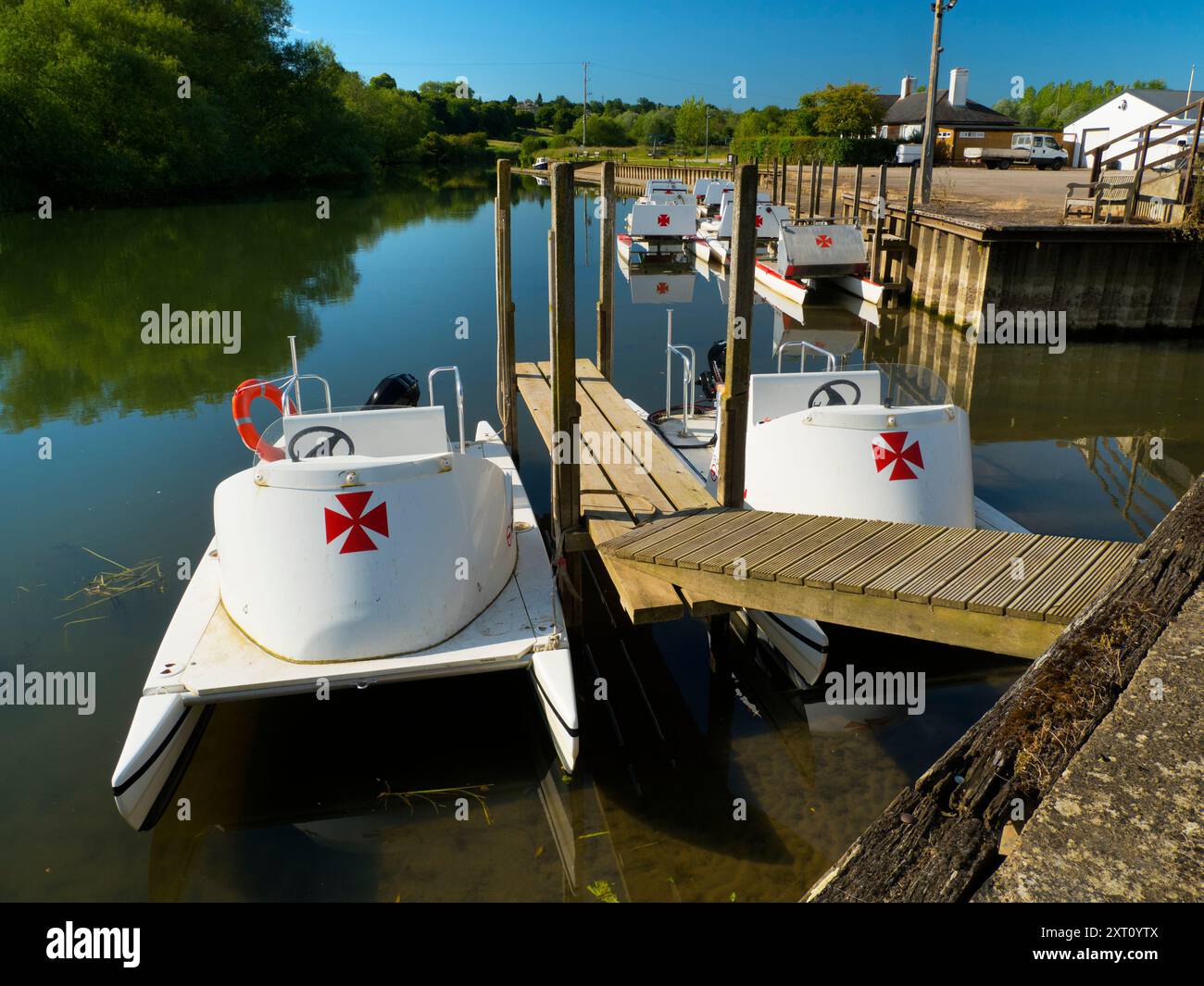 Fondé en 1921 et situé sur une belle partie de la Tamise dans l'Oxfordshire, Radley Boathouse sert Radley College et les amateurs d'aviron locaux depuis plus d'un siècle. Ici, nous voyons une ligne de bateaux de plaisance amarrés par sa jetée, tôt par un beau matin de printemps. Pourquoi la Croix de Malte ? C'est une longue histoire... Il a été adopté à l'origine par le Collège comme badge pour tous les sports vers 1850. Il est devenu le symbole du Boat Club à partir de la première équipe connue, et a probablement été adopté en l'honneur de Sir George Bowyer, le propriétaire de Radley Hall et à qui la maison et les terrains ont été loués quand t Banque D'Images