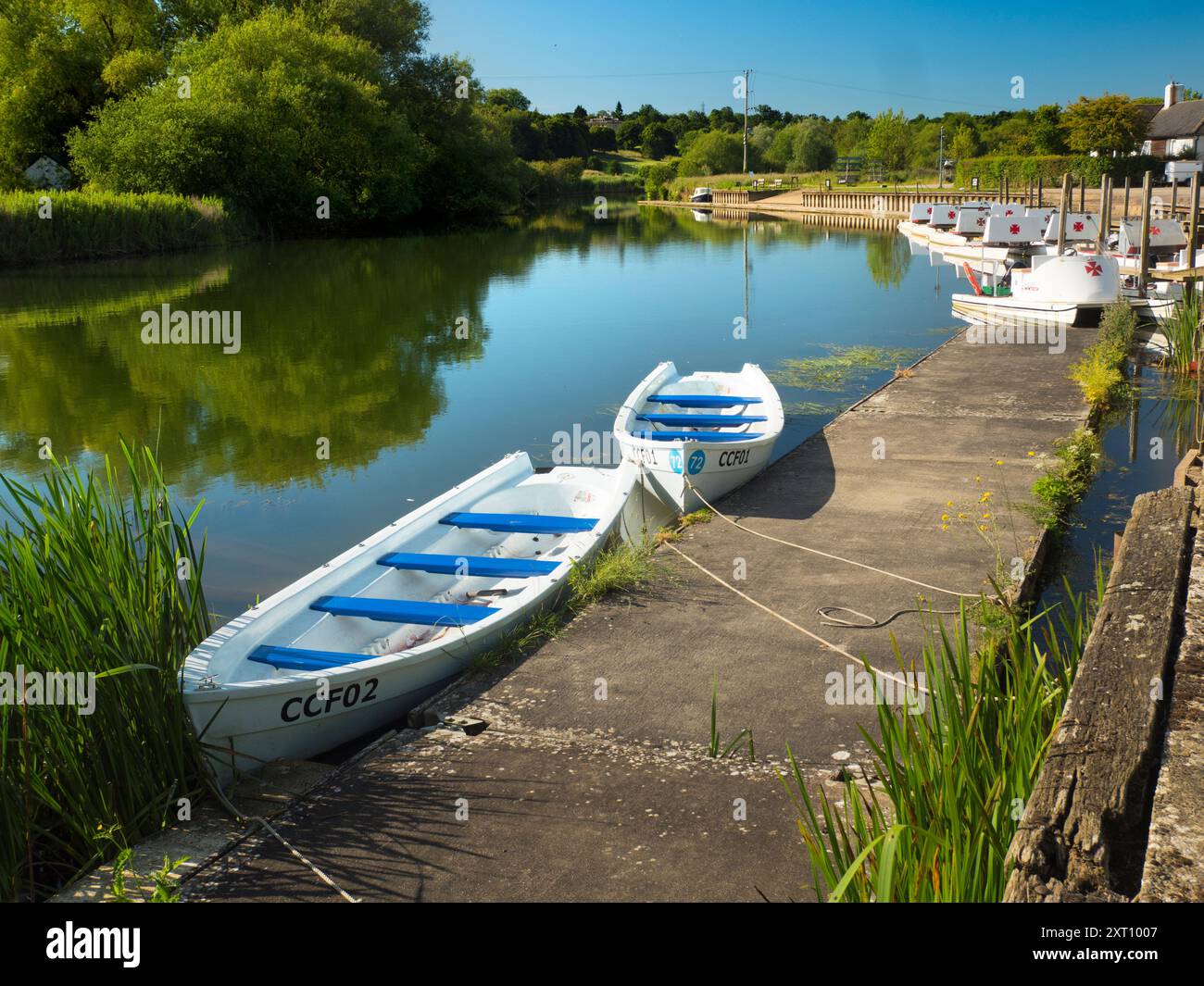 Fondé en 1921 et situé sur une belle partie de la Tamise dans l'Oxfordshire, Radley Boathouse sert Radley College et les amateurs d'aviron locaux depuis plus d'un siècle. Ici, nous voyons une ligne de bateaux de plaisance amarrés par sa jetée, tôt par un beau matin de printemps. Banque D'Images