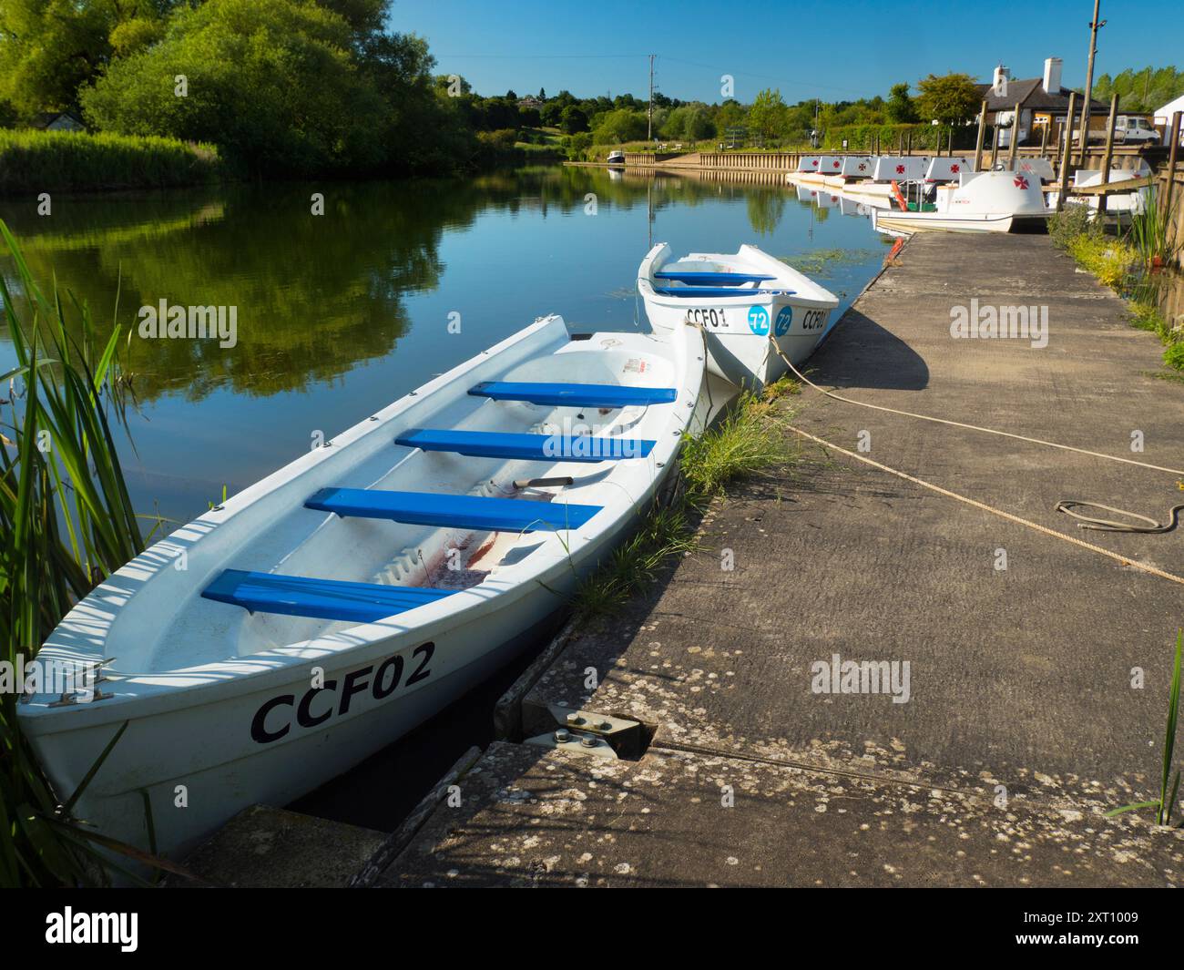 Fondé en 1921 et situé sur une belle partie de la Tamise dans l'Oxfordshire, Radley Boathouse sert Radley College et les amateurs d'aviron locaux depuis plus d'un siècle. Ici, nous voyons une ligne de bateaux de plaisance amarrés par sa jetée, tôt par un beau matin de printemps. Banque D'Images