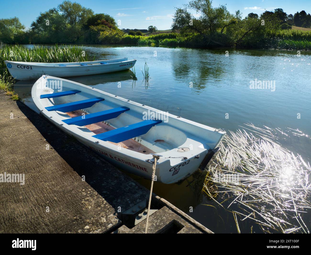 Fondé en 1921 et situé sur une belle partie de la Tamise dans l'Oxfordshire, Radley Boathouse sert Radley College et les amateurs d'aviron locaux depuis plus d'un siècle. Ici, nous voyons deux bateaux à rames amarrés par sa jetée, tôt par un beau matin d'été. Banque D'Images