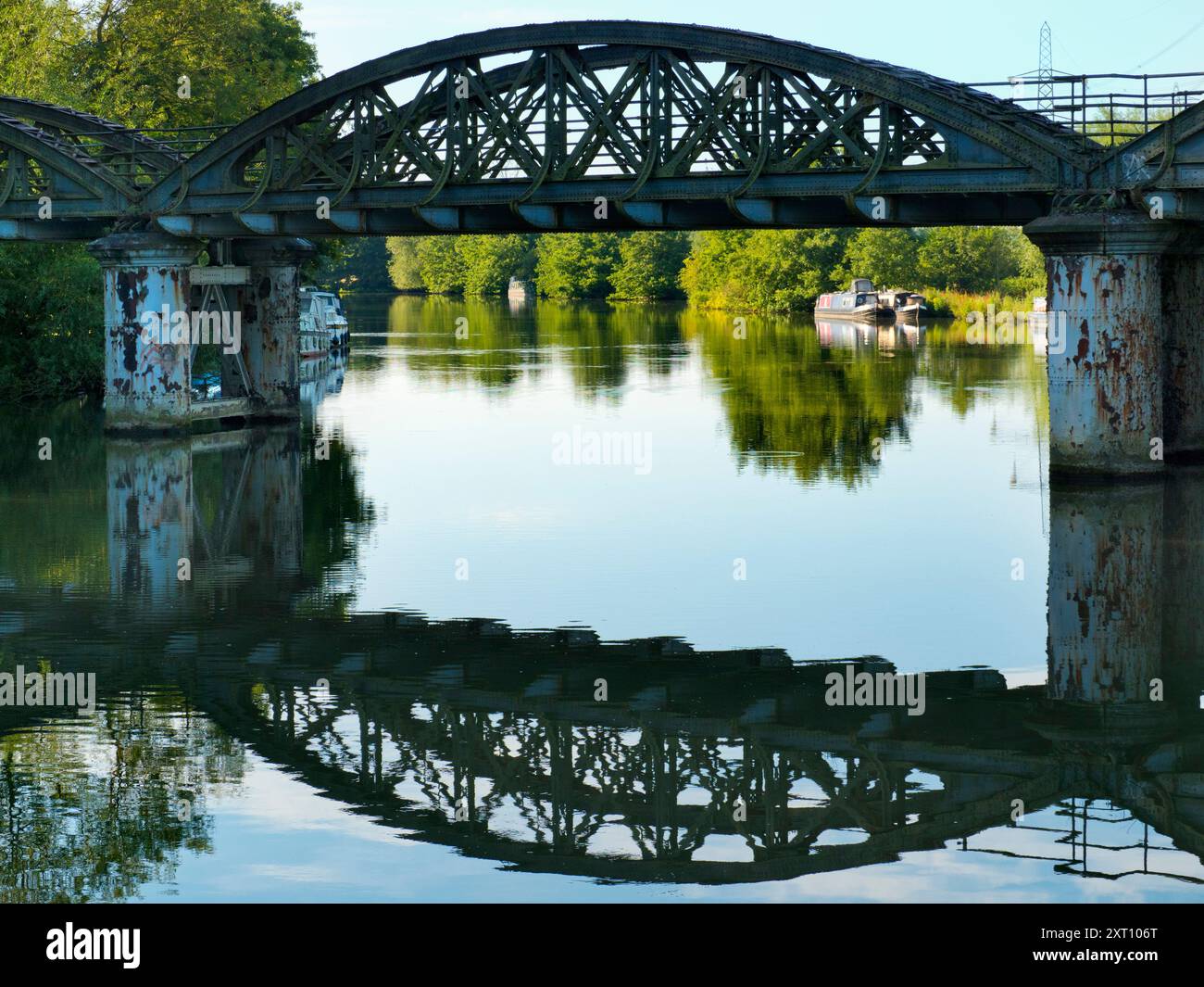 Une partie pittoresque de la Tamise qui rejoint Hinksey Stream à Kennington. Les pylônes géants abondent, et le Thames Path court à notre droite. La scène est dominée par un pont ferroviaire rouillé et abandonné, inutilisé depuis de nombreuses années. Tout brille avec la première lumière sur un beau matin de milieu d'été. Adorable. Banque D'Images