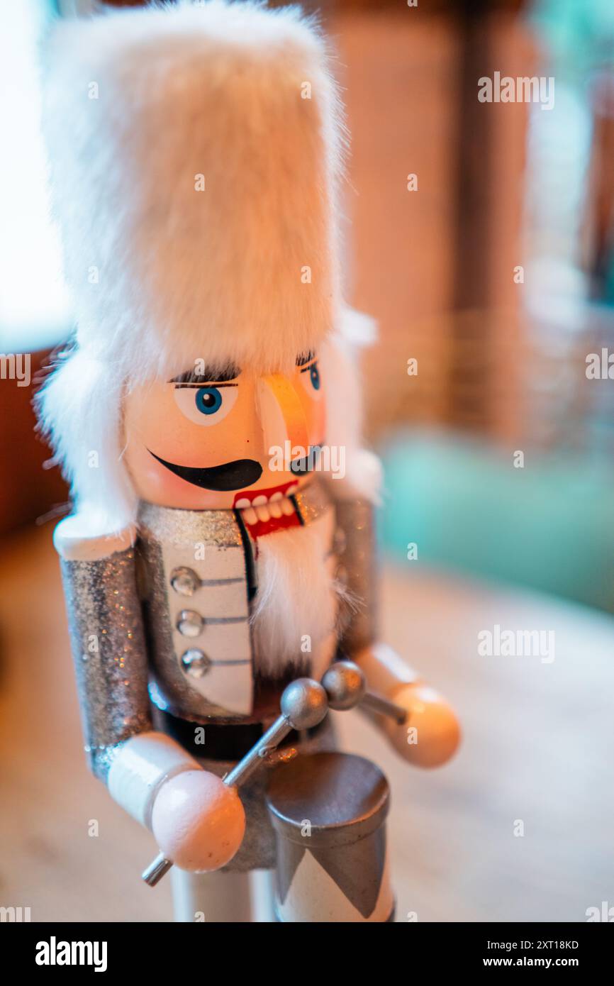 Casse-noisette blanc décoratif avec fourrure blanche Bearskin Hat un costume argenté et un tambour debout sur une table avec un sapin en céramique Banque D'Images