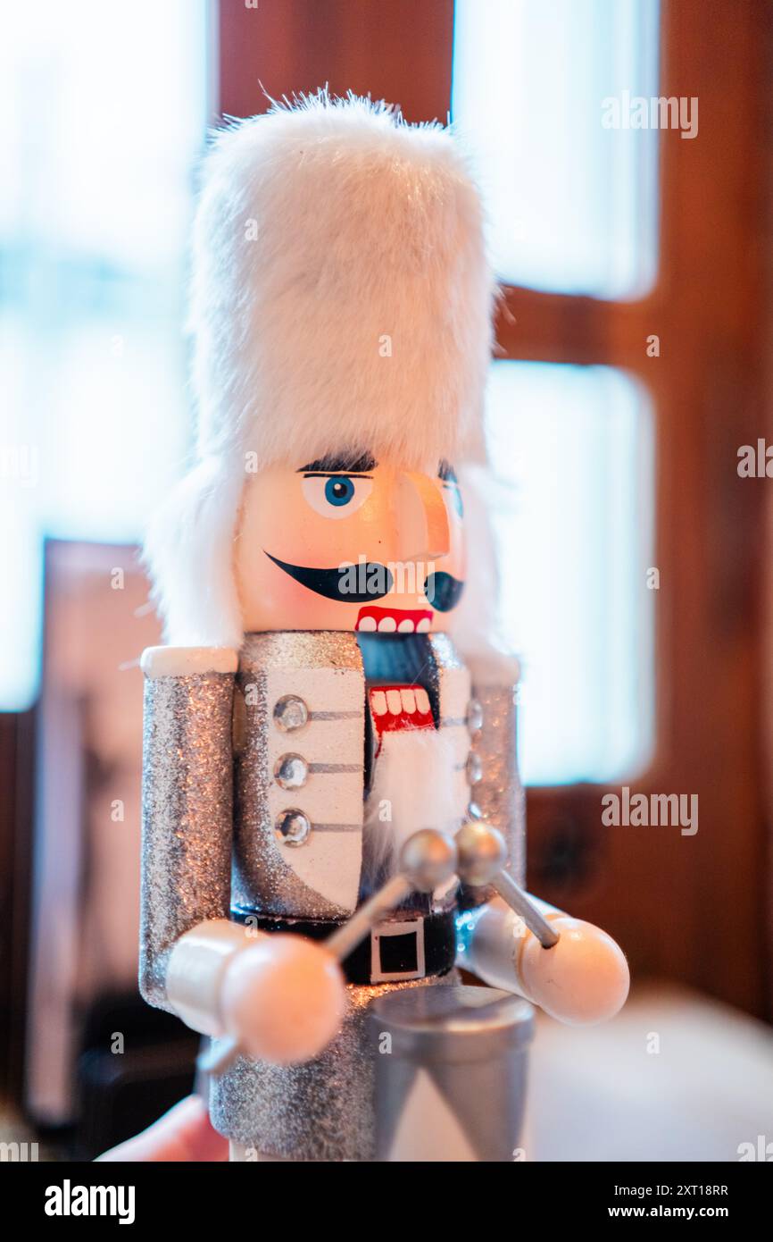Casse-noisette blanc décoratif avec fourrure blanche Bearskin Hat un costume argenté et un tambour debout sur une table avec une bouche ouverte Banque D'Images