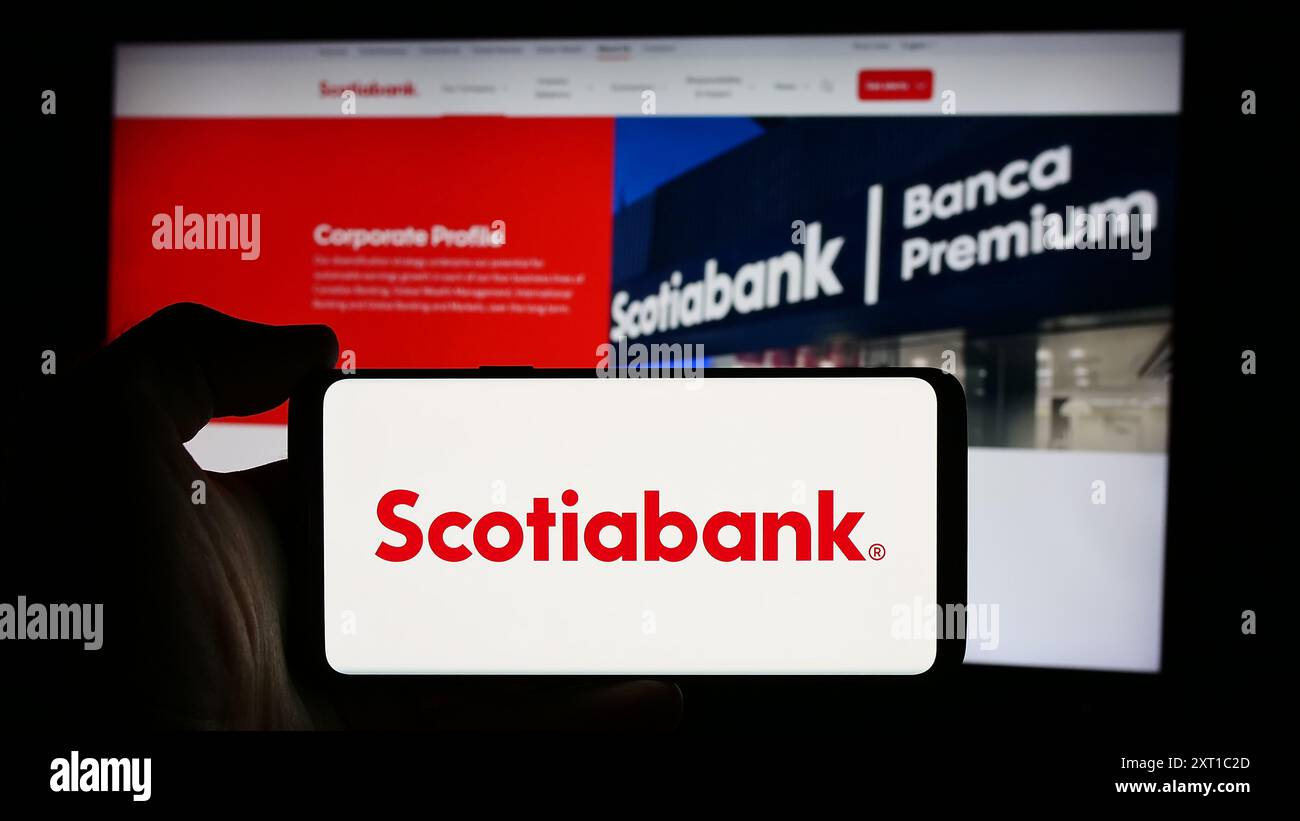 Personne tenant un téléphone cellulaire avec le logo de la société financière Bank of Nova Scotia (Scotiabank) devant la page Web de l'entreprise. Concentrez-vous sur l'affichage du téléphone. Banque D'Images Personne tenant un téléphone cellulaire avec le logo de la société financière Bank of Nova Scotia (Scotiabank) devant la page Web de l'entreprise. Concentrez-vous sur l'affichage du téléphone. Banque D'Images