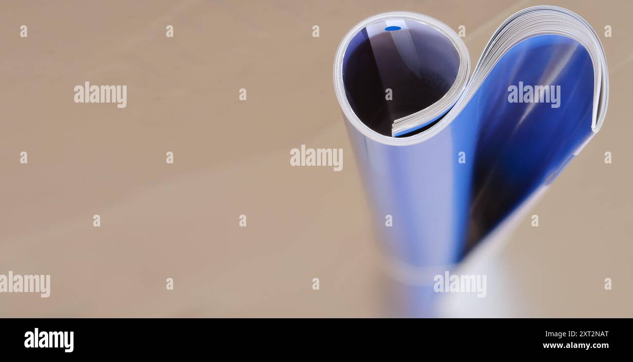 Magazine enroulé, journal, mise au point sélective et peu profonde, arrière-plan flou, espace de copie Banque D'Images