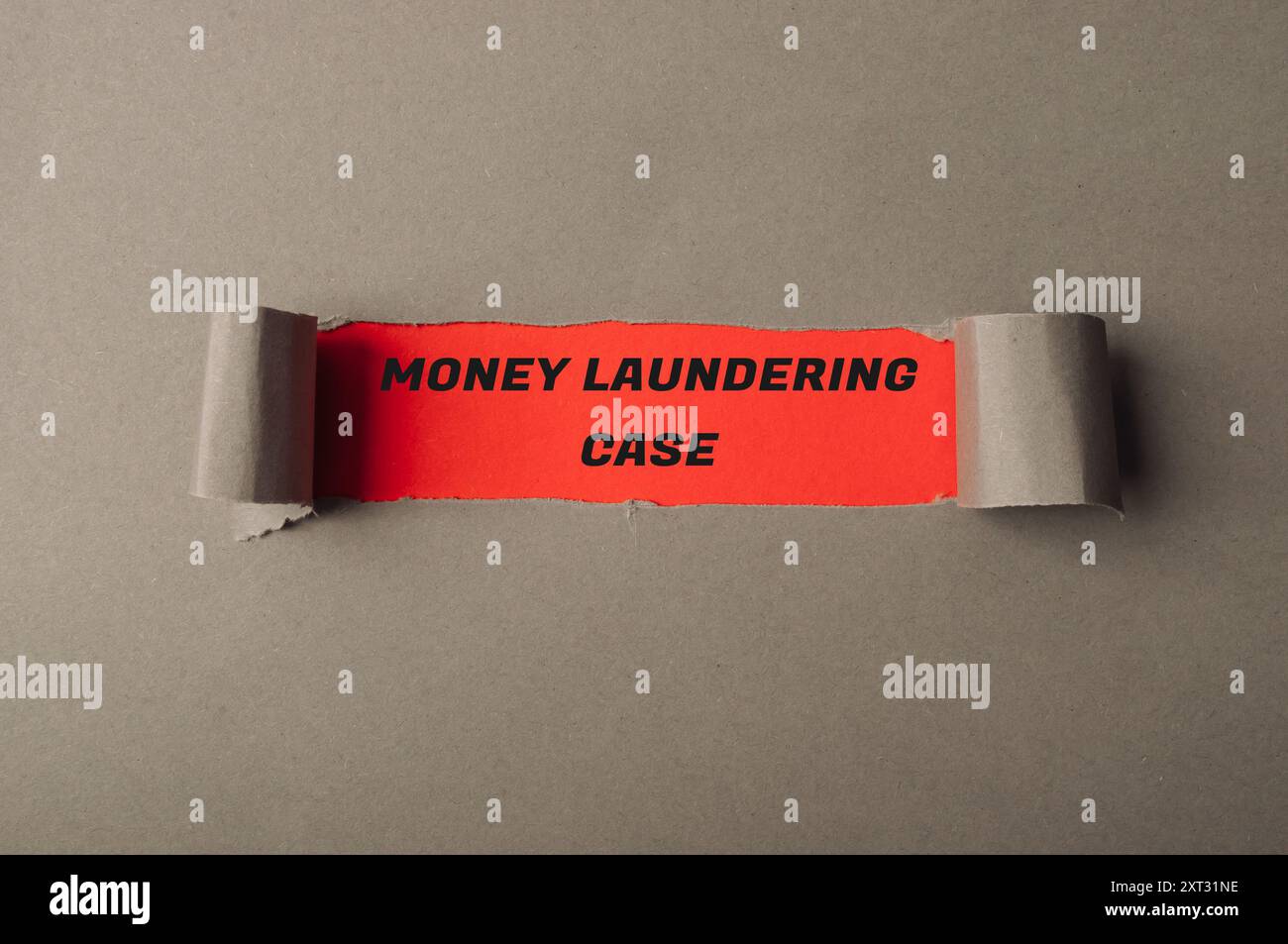 Un morceau de papier déchiré avec les mots Money blanchiment case écrit dessus. Le papier est rouge et blanc, et il est déchiré en deux. Notion d'urgence et Banque D'Images