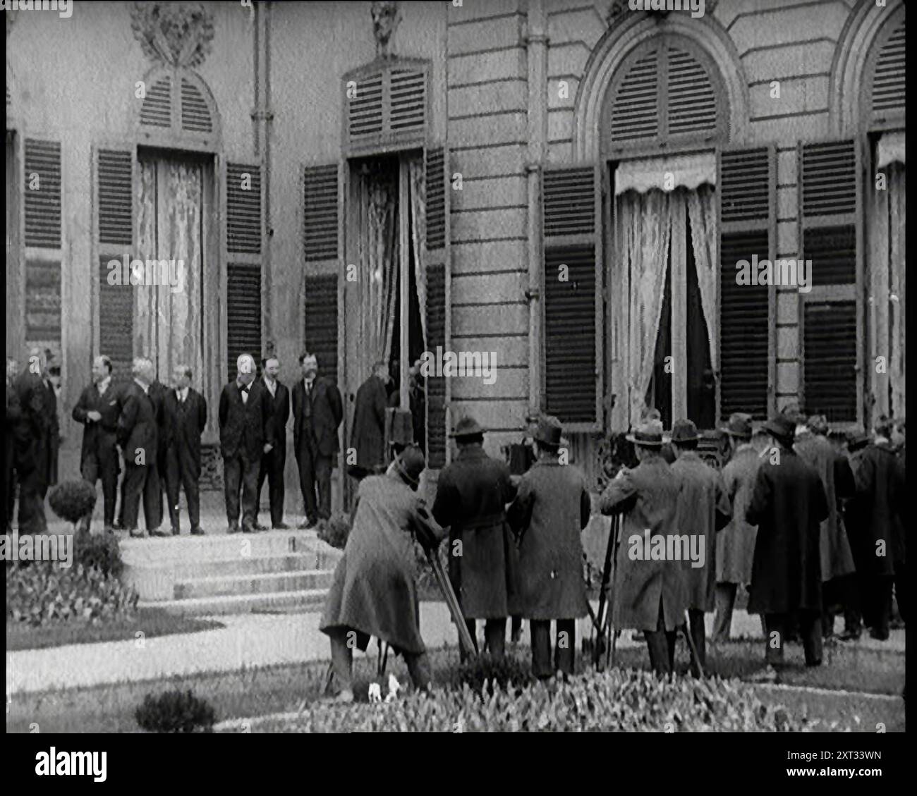 Nouveau gouvernement français debout photographié, filmé et interviewé par des journalistes, années 1920 '...la France, encore une fois en proie à des troubles politiques, avec un nouveau gouvernement tous les deux mois...'. De "Time to Remember - came the Dawn", 1925 (Reel 3) ; aperçu de l'industrie cinématographique britannique des années 1920 - extraits de grands films muets et de nouvelles. Banque D'Images