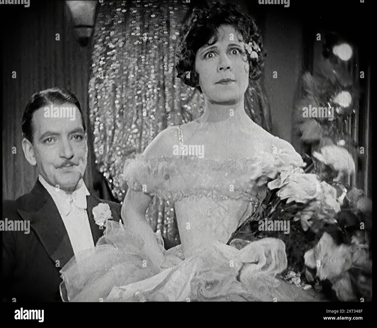 Scène du film 'le mari obligatoire' : un acteur féminin assis sur un acteur masculin Lap, 1920s. De "Time to Remember - came the Dawn", 1925 (Reel 3) ; aperçu de l'industrie cinématographique britannique des années 1920 - extraits de grands films muets et de nouvelles. Banque D'Images