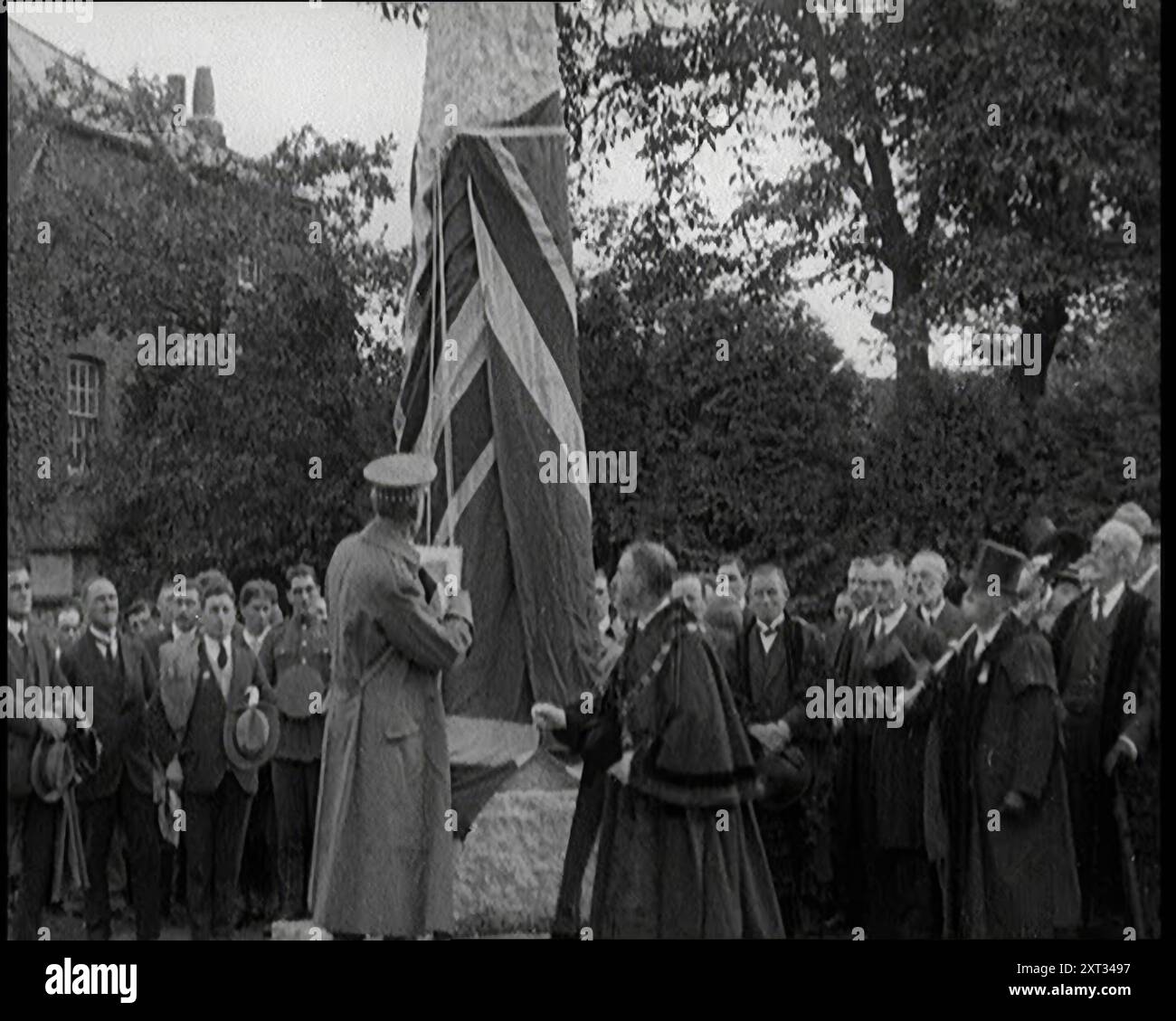 Officier britannique tirant vers le bas le drapeau de l'Union pour révéler un obélisque commémoratif, 1920. '... une époque de civilisations mêlées encore au kaki, de grands dévoilements... quand, sur une centaine de champs de bataille fraîchement ensanglantés, des maréchaux et généraux et des chapeaux en laiton ont posé assez de pierres pour construire une maison de taille convenable. Alors que dans un millier de villes et de villages à travers l'Europe qui souffre depuis longtemps, d'autres PERSONNALITÉS ont retiré des drapeaux des obélisques de la Grande Guerre, des plaques de la Grande Guerre et des cénotaphes de la Grande Guerre, des pierres symbolisant la chair et le sang, des monuments commémoratifs dont il faut se souvenir. Le ciel sait qu'il y en avait assez pour se souvenir. Des millions, la fleur des Nations Banque D'Images