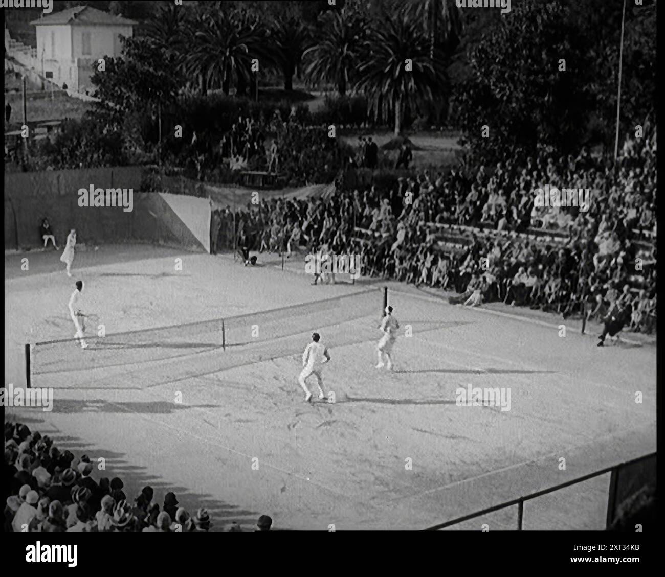 Les joueuses de tennis Suzanne Lenglen, de France, et Helen Wills, des États-Unis d’Amérique, disputent un match avec deux civils masculins devant une foule nombreuse, 1926 ans. De "Time to Remember 1926 - Short Sharp Shower" ( Reel 3) ; documentaire sur 1926 - grève générale, politique internationale, danse, météo et exploits record. Banque D'Images