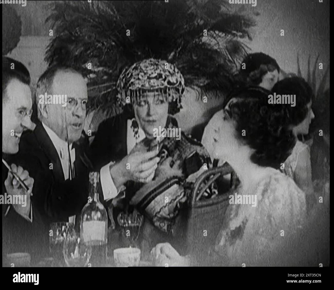 Hommes et femmes britanniques assis et parlant et fumant à une table dans une boîte de nuit, 1922. De "Time to Remember - Sitting Still and Going Slowly", 1922 (bobine 1) ; revue des événements de 1922, y compris les troubles irlandais, la guerre entre la Grèce et la Turquie et les développements dans l'aviation et la radio. Banque D'Images