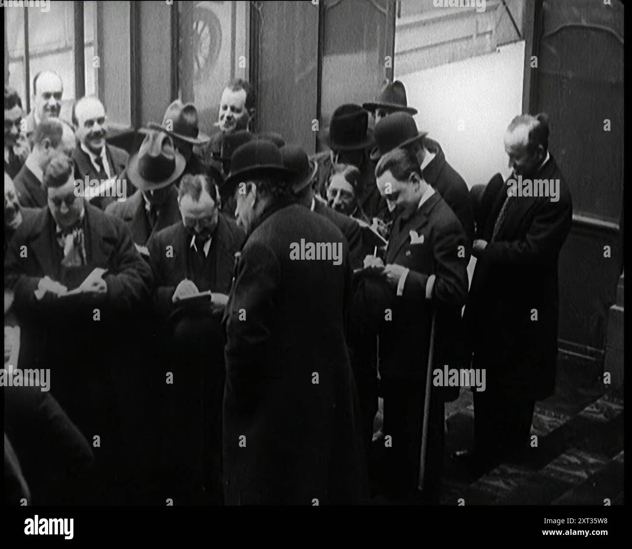 Nouveau gouvernement français debout photographié, filmé et interviewé par des journalistes, années 1920 '...la France, encore une fois en proie à des troubles politiques, avec un nouveau gouvernement tous les deux mois...'. De "Time to Remember - came the Dawn", 1925 (Reel 3) ; aperçu de l'industrie cinématographique britannique des années 1920 - extraits de grands films muets et de nouvelles. Banque D'Images