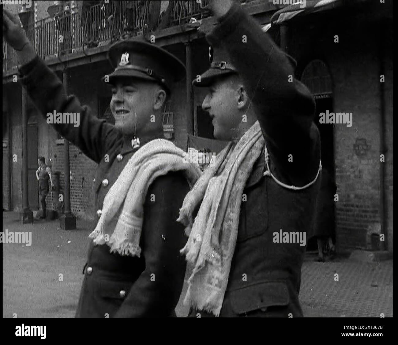 Deux soldats britanniques en uniforme avec les armes levées debout devant Brick Building, 1937. Pratiquant pour le couronnement du roi George IV. '... les tambours, les bugles et les hochets à la caserne. De "Time to Remember - Sense of Values", 1937 (bobine 1) ; film documentaire sur les événements de 1937, la guerre en extrême-Orient, construire à la guerre en Europe. Banque D'Images