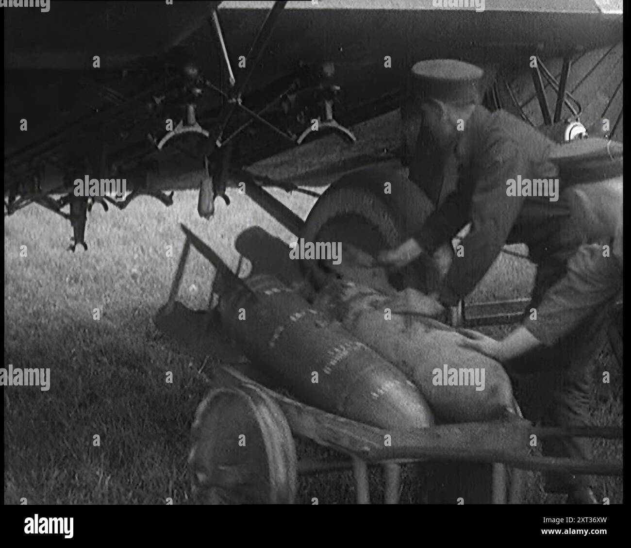 Officiers britanniques hommes chargeant des bombes sur un avion, années 1920 De "Time to Remember - Fast and Far in the Twenties", 1927 (Reel 2 - Record B) ; un regard sur l'obsession de la vitesse et du voyage à la fin des années 1920 Banque D'Images