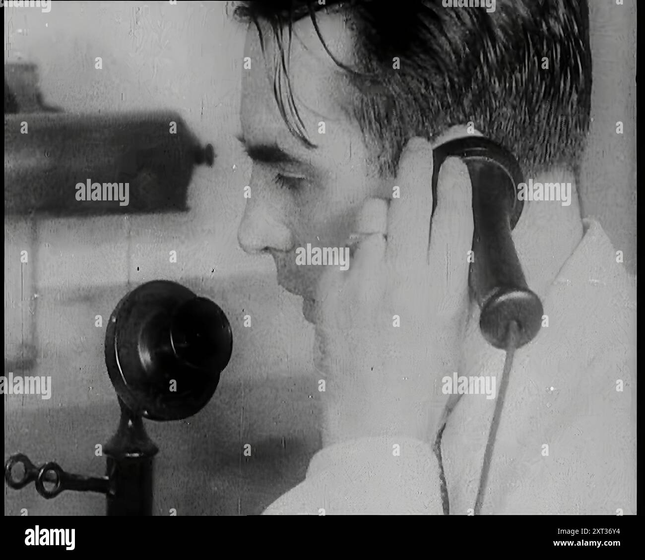 Un homme britannique tenant un chandelier récepteur téléphonique à l'oreille et parlant dans la pièce à mordre, 1939. De "Time to Remember - The Reluctant Warriors", 1939 ( Reel 2) ; documentaire sur les événements de 1939 - les préparatifs pour la guerre et les hostilités éclatent. Banque D'Images