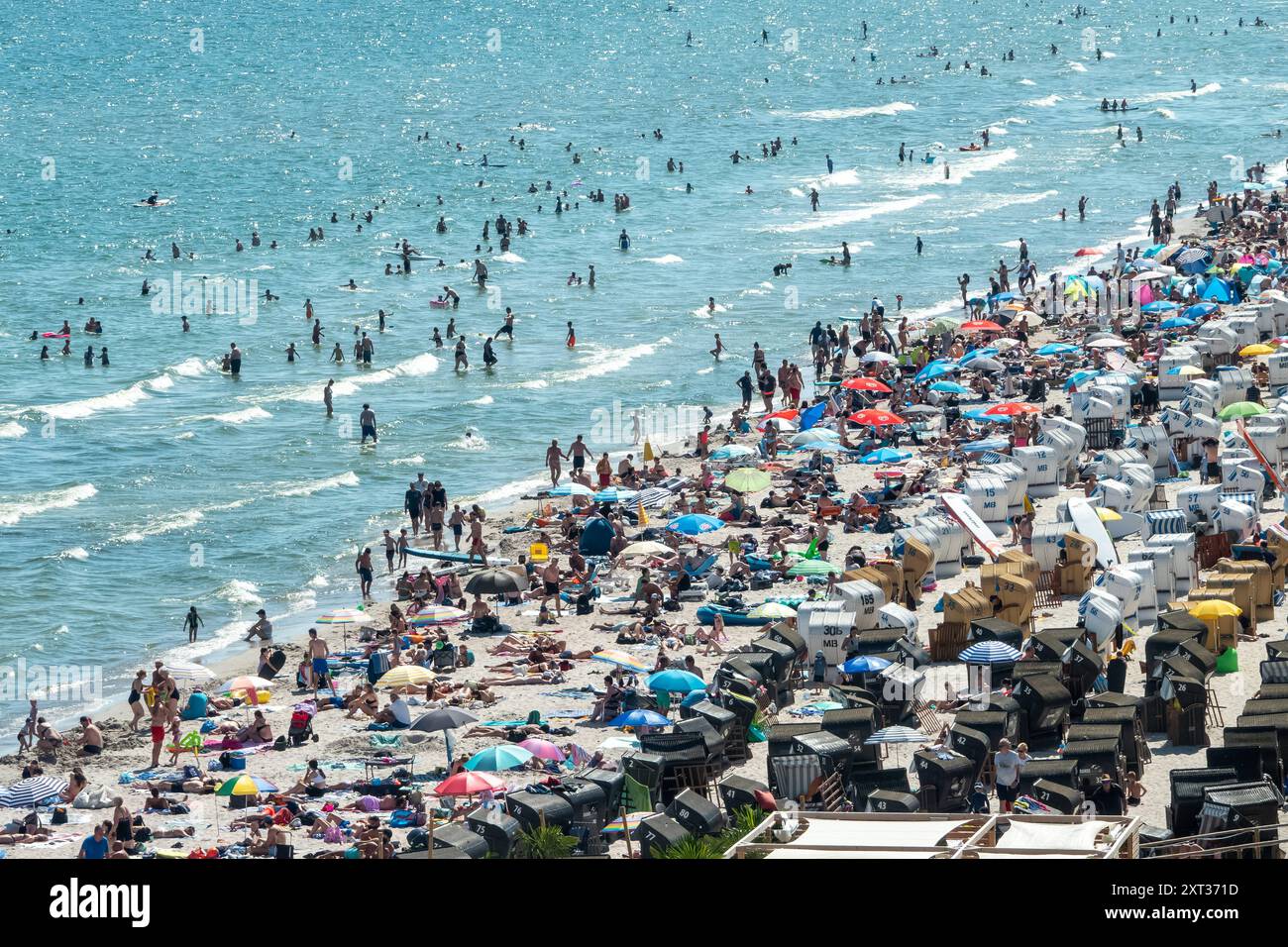 Voller Sommerstrand in Scharbeutz Das Bild zeigt einen vollen Strand in Scharbeutz an der Ostseeküste an einem sonnigen heißen Sommertag. Der Strand ist dicht besetzt mit Strandkörben, bunten Sonnenschirmen und zahlreichen Badegästen, die das warme Wetter genießen. IM Wasser tummeln sich Menschen, die schwimmen oder einfach im seichten Wasser stehen. An vielen Orten in Deutschland könnte es heute der bislang heißeste Tag des Jahres werden. Scharbeutz Schleswig-Holstein Deutschland *** plage d'été complète à Scharbeutz L'image montre une plage complète à Scharbeutz sur la côte de la mer Baltique sur un chaud Banque D'Images
