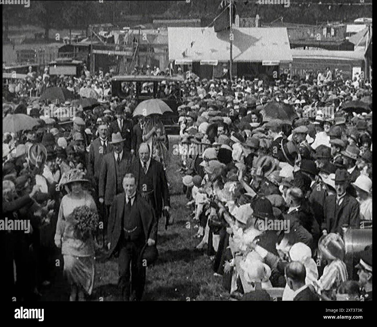 Un groupe de politiciens marchant à travers une grande foule de gens, les années 1920 "En Grande-Bretagne dans les années vingt, c'était un monde pour la plupart du temps, sous la direction de Stanley Baldwin". De "Time to Remember - came the Dawn", 1925 (Reel 2) ; aperçu de l'industrie cinématographique britannique des années 1920 - extraits de grands films muets et de nouvelles. Banque D'Images