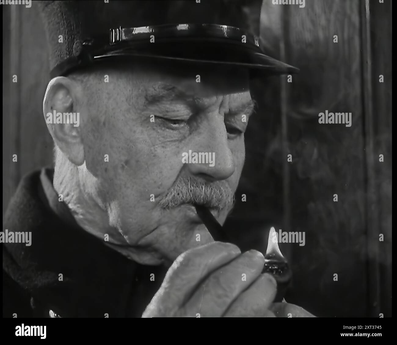 Gros plan sur le retraité britannique masculin de Chelsea comme il est l'éclairage d'un tuyau, 1939. De "Time to Remember - The Reluctant Warriors", 1939 (bobine 1) ; documentaire sur les événements de 1939 - les préparatifs de la guerre et les hostilités éclatent. Banque D'Images