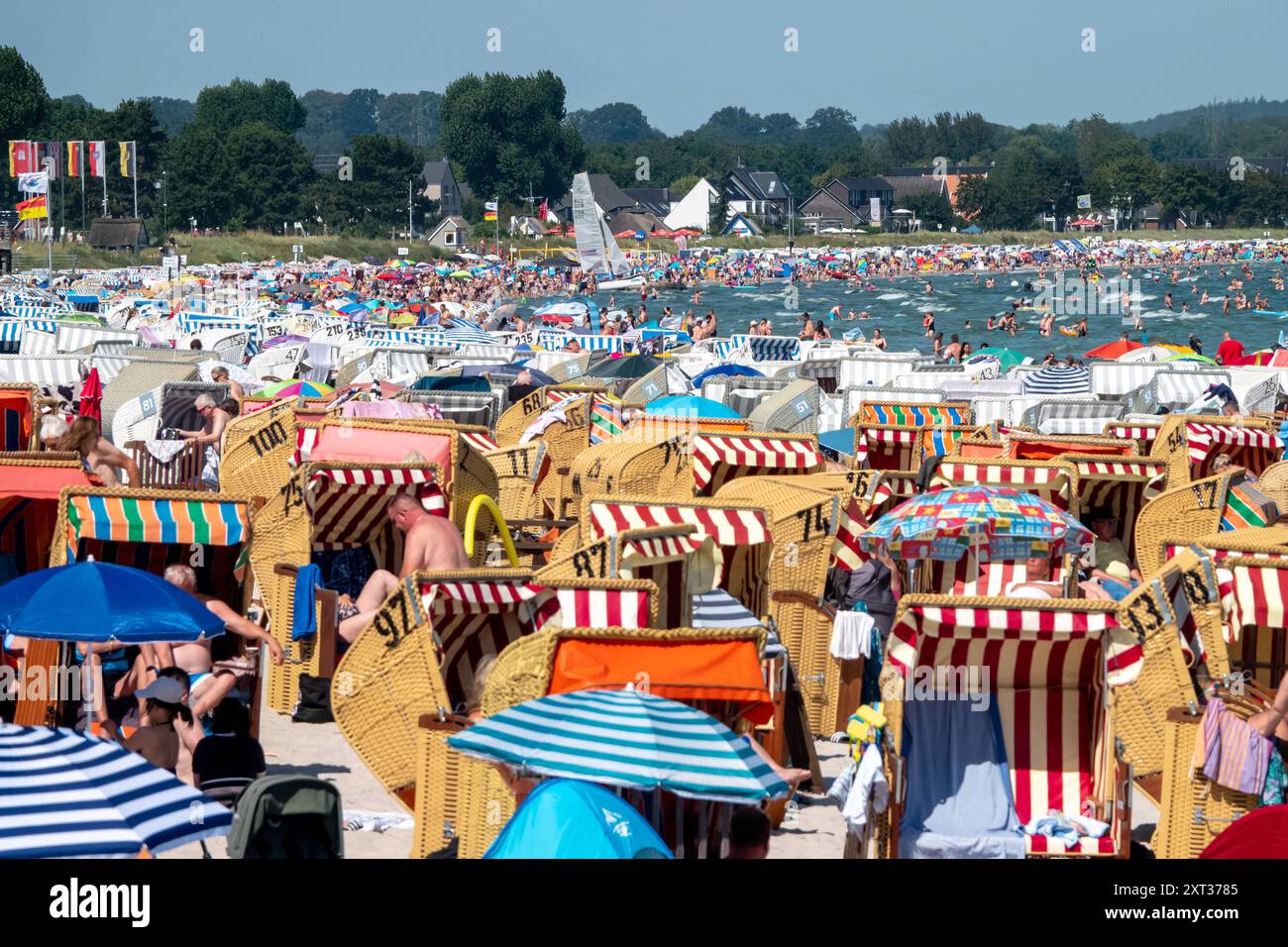 Voller Sommerstrand in Scharbeutz Das Bild zeigt einen vollen Strand in Scharbeutz an der Ostseeküste an einem sonnigen heißen Sommertag. Der Strand ist dicht besetzt mit Strandkörben, bunten Sonnenschirmen und zahlreichen Badegästen, die das warme Wetter genießen. IM Wasser tummeln sich Menschen, die schwimmen oder einfach im seichten Wasser stehen. An vielen Orten in Deutschland könnte es heute der bislang heißeste Tag des Jahres werden. Scharbeutz Schleswig-Holstein Deutschland *** plage d'été complète à Scharbeutz L'image montre une plage complète à Scharbeutz sur la côte de la mer Baltique sur un chaud Banque D'Images