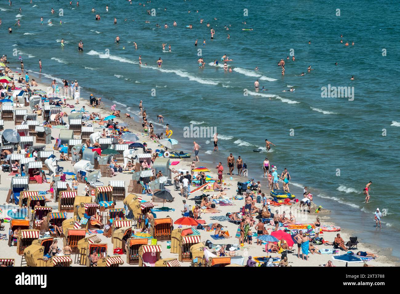 Voller Sommerstrand in Scharbeutz Das Bild zeigt einen vollen Strand in Scharbeutz an der Ostseeküste an einem sonnigen heißen Sommertag. Der Strand ist dicht besetzt mit Strandkörben, bunten Sonnenschirmen und zahlreichen Badegästen, die das warme Wetter genießen. IM Wasser tummeln sich Menschen, die schwimmen oder einfach im seichten Wasser stehen. An vielen Orten in Deutschland könnte es heute der bislang heißeste Tag des Jahres werden. Scharbeutz Schleswig-Holstein Deutschland *** plage d'été complète à Scharbeutz L'image montre une plage complète à Scharbeutz sur la côte de la mer Baltique sur un chaud Banque D'Images